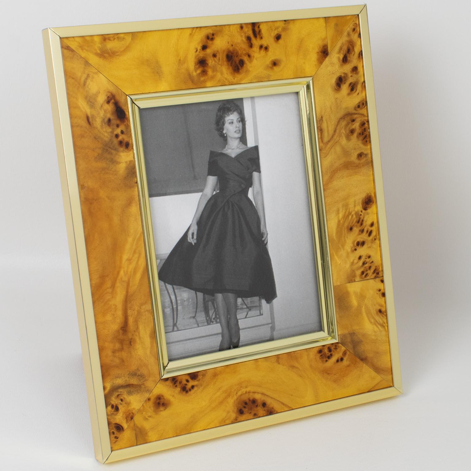 Montagnani Firenze, Italy, crafted this stunning picture photo frame in the 1970s. Its Mid-Century modernist design boasts a rectangular shape, with light burl walnut wood geometric veneer complimented with polished gilded aluminum metal framings.