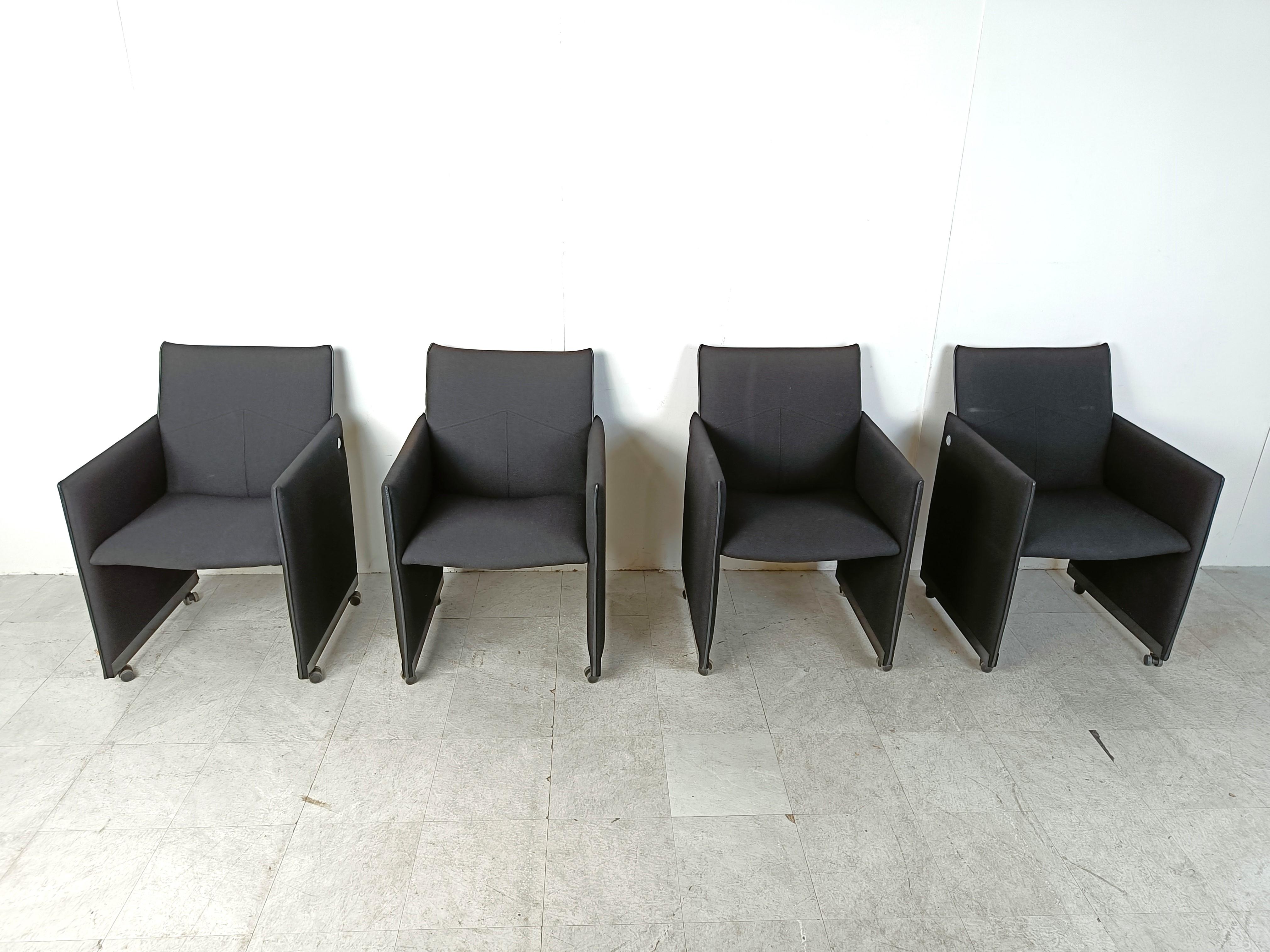 Set of 4 black fabric armchairs on casters designed by Geoffrey Harcourt for Artifort.

The chairs are labeled on the side with a round metal plate and marked underneath the seates.

Handy casters make the chairs easy to move. The chairs are also