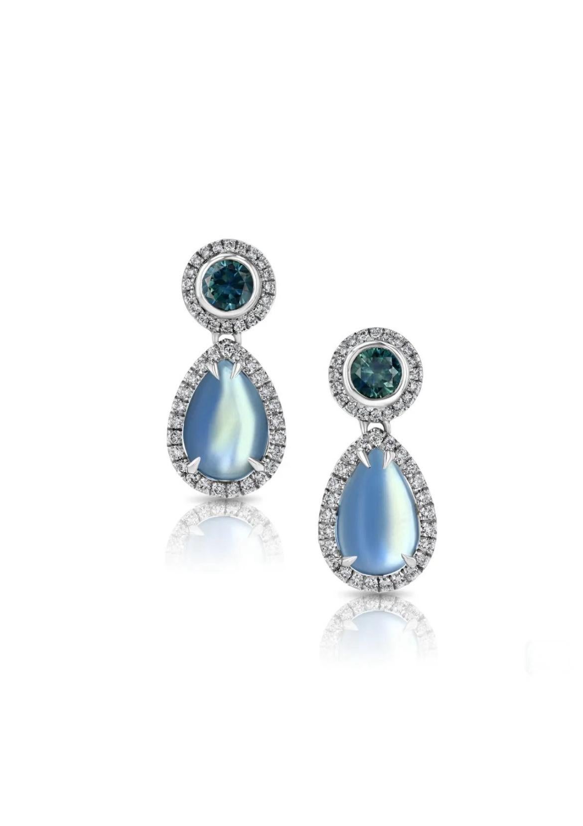 18K white gold earrings, featuring two luminous pear-shaped Moonstones totaling 7.67cts, paired with two round Montana Sapphires totaling  1.54cts, accented by twinkling round diamonds totaling 0.71cts. 

Moonstone’s delicate beauty and its