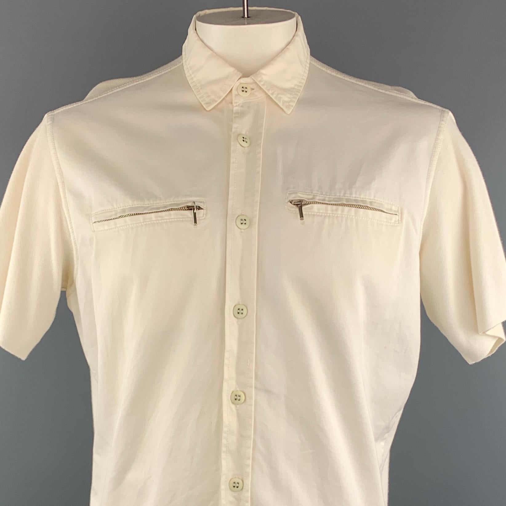 VINTAGE MONTANA short sleeve shirt comes in a off white cotton featuring a button up style, front zipper pockets, and a spread collar. Made in Italy.
 
Very Good Pre-Owned Condition.
Marked: (No size)
 
Measurements:
 
Shoulder: 18 in.
Chest: 48