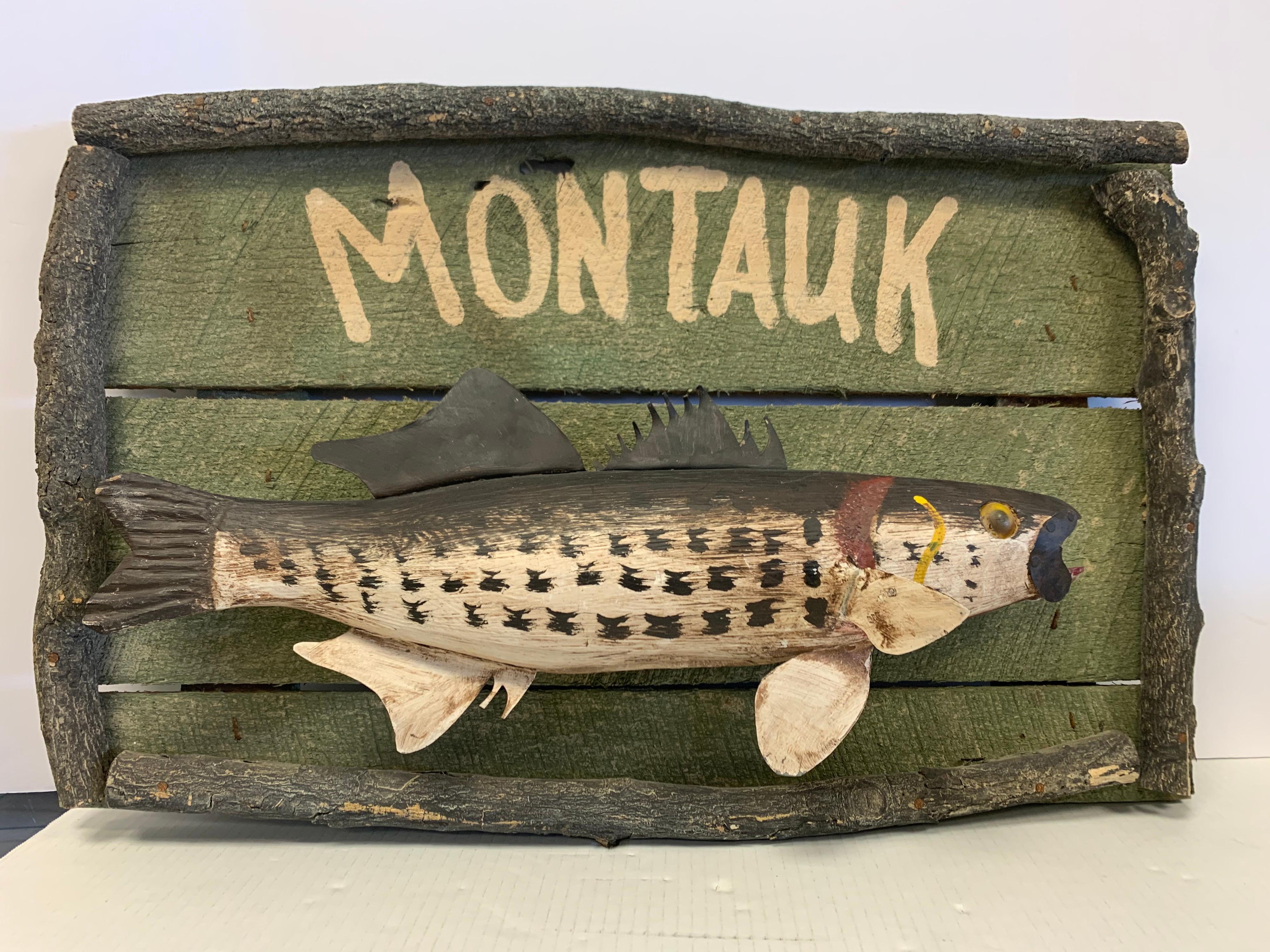 Vintage, one-of-a-kind folk art painted Montauk sign of a three dimensional carved fish mounted on wood. Framed with tree branches all around.  