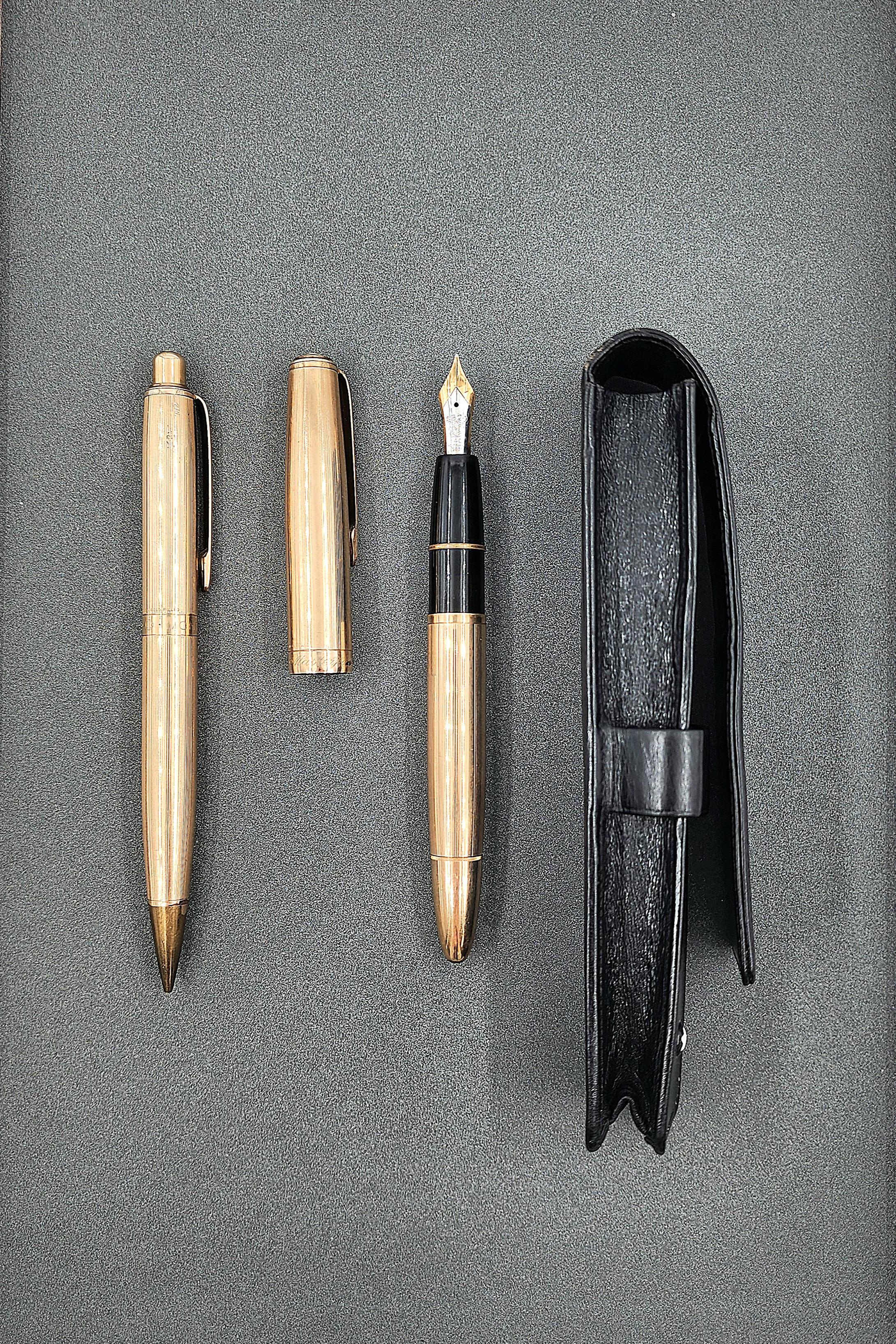 Ce set d'écriture sophistiqué se compose d'une paire de stylos à la finition dorée raffinée. Le corps des stylos est élégamment texturé, complété par des clips élégants. Accompagné d'un étui en cuir noir, l'ensemble dégage un attrait intemporel.