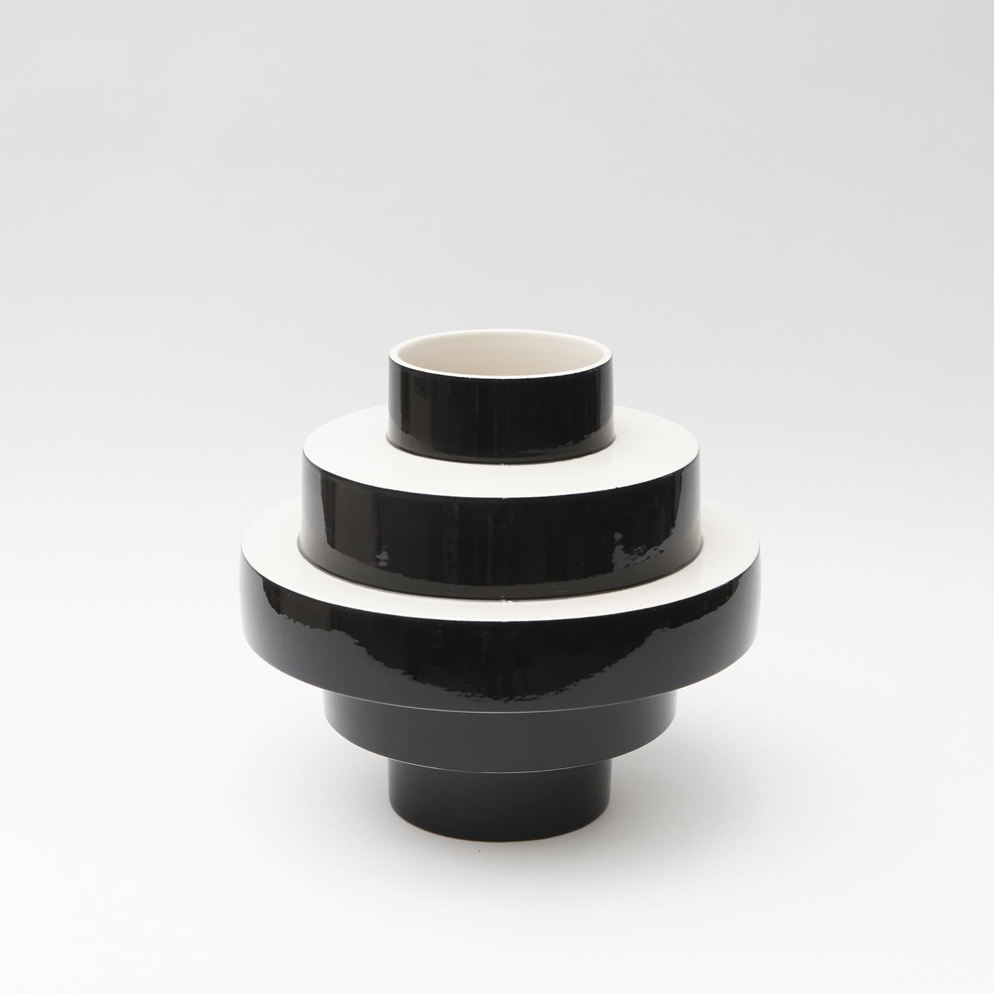 With a dynamic and elegant design, the Monté vase is entirely hand crafted in gloss black ceramic. The clever shape features layers of concentric circles widening in the middle and becoming narrow at the top and bottom. Display your favorite flowers