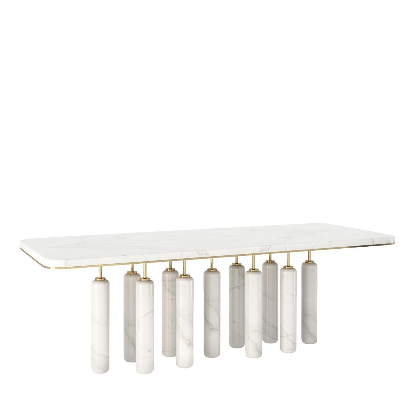 Showcasing a majestic and sculptural silhouette, this sophisticated dinner table will be an eye-catching piece in the most refined interiors. The rectangular marble top with beveled corners is embellished with a thin brass-finished metal frame and