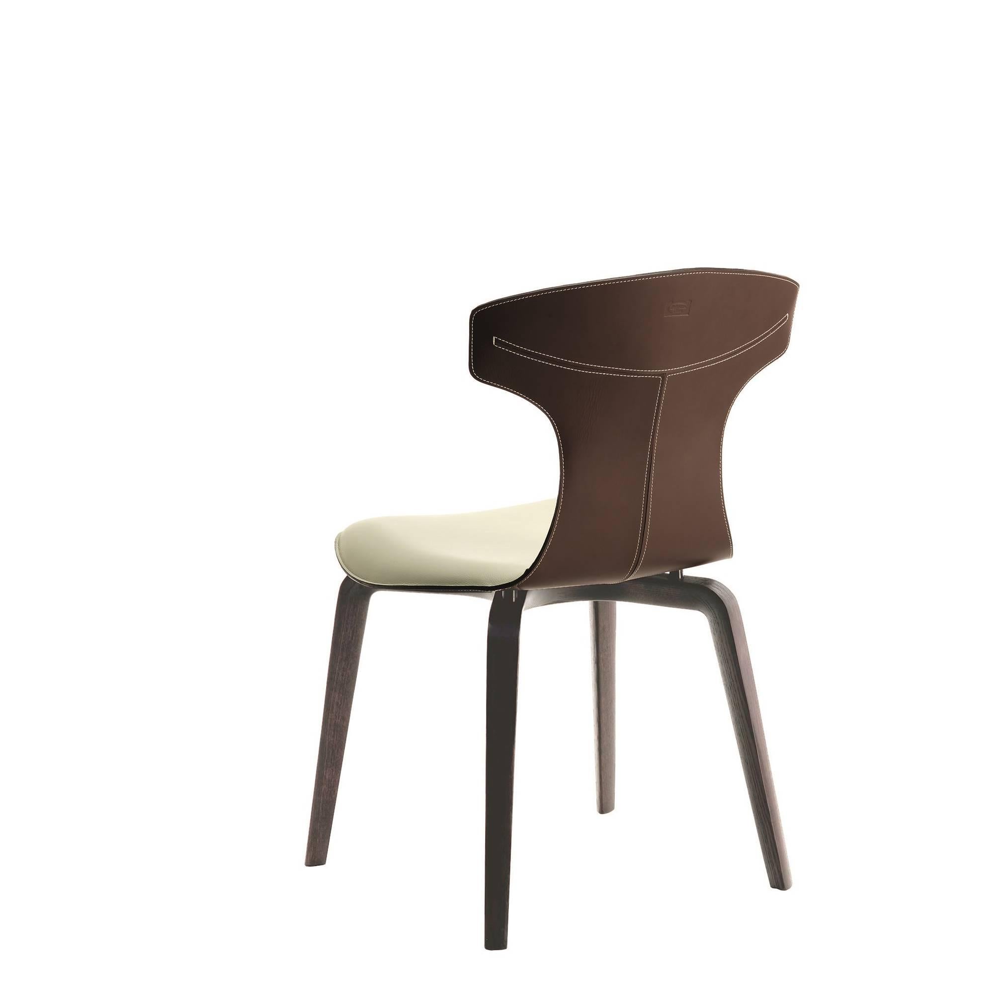 La chaise Montera, conçue par Roberto Lazzeroni pour Poltrona Frau, a une légèreté formelle qui exprime le charme sensoriel de ses matériaux : le traitement brut de coupe exalte la tactilité du cuir de selle et du cuir qui, combinés ensemble, se