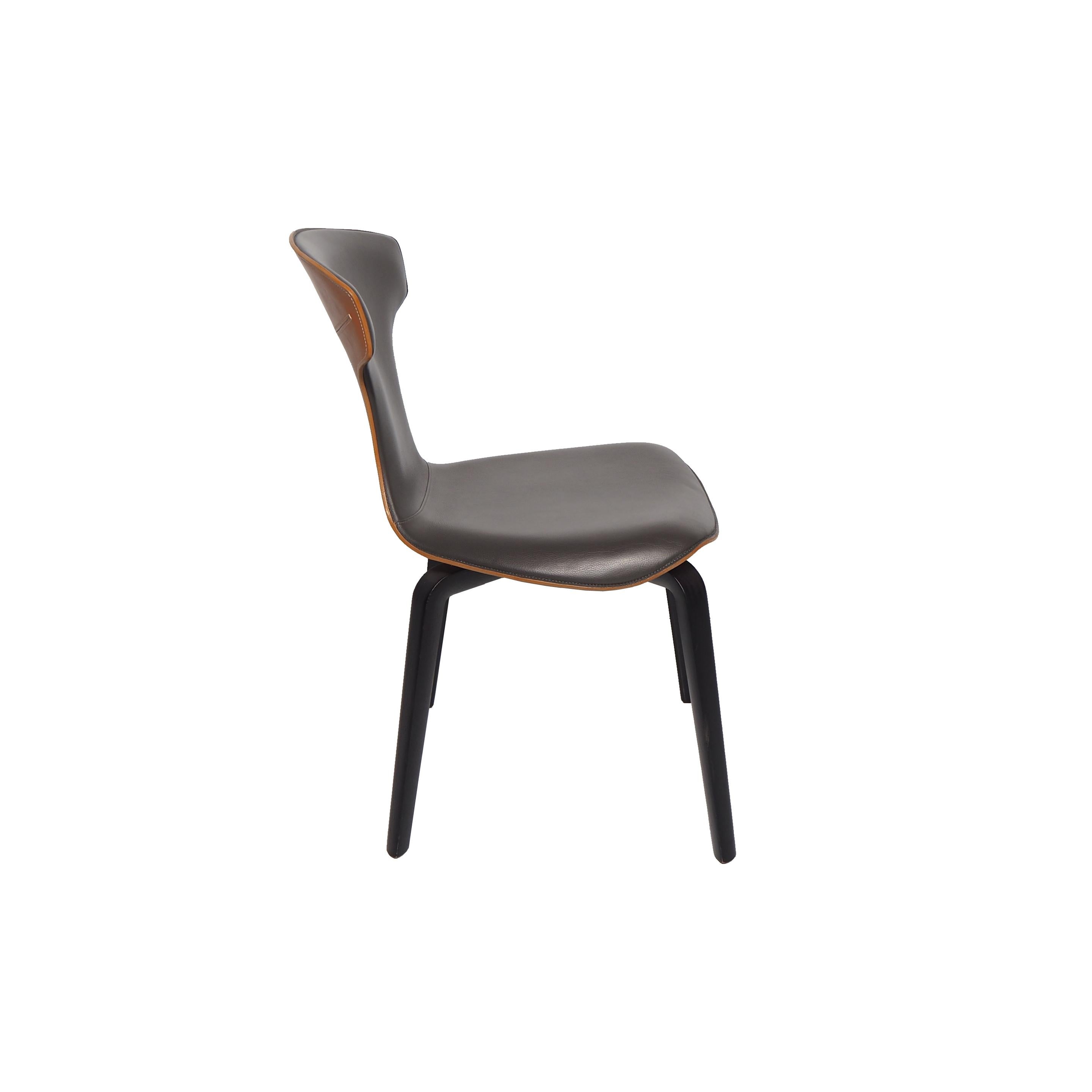 La chaise Montera, conçue par Roberto Lazzeroni pour Poltrona Frau, a une légèreté formelle qui exprime le charme sensoriel de ses matériaux : le traitement brut de coupe exalte la tactilité du cuir de selle et du cuir qui, combinés ensemble, se