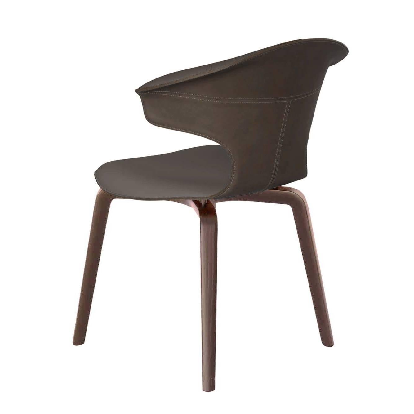 La chaise Montera avec accoudoirs conçue par Roberto Lazzeroni présente une légèreté formelle qui exprime le charme sensoriel de ses matériaux : le traitement brut de coupe exalte la tactilité du cuir de selle et du cuir qui, combinés ensemble, se