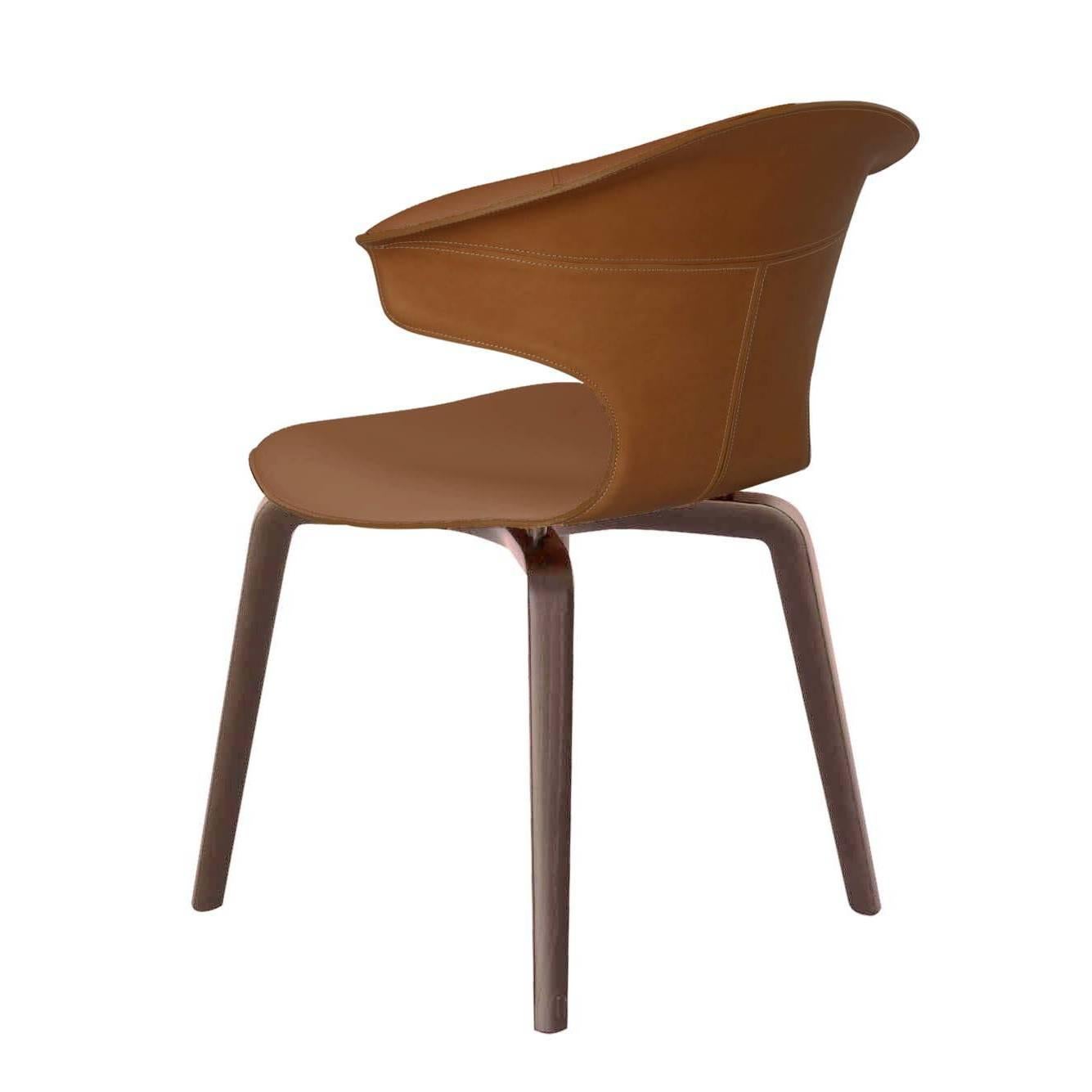 The Montera chair with arms designed by Roberto Lazzeroni has a formal lightness that expresses the sensory charm of its materials: the raw cut processing exalts the tactility of the saddle-leather and leather which, combined together, complement