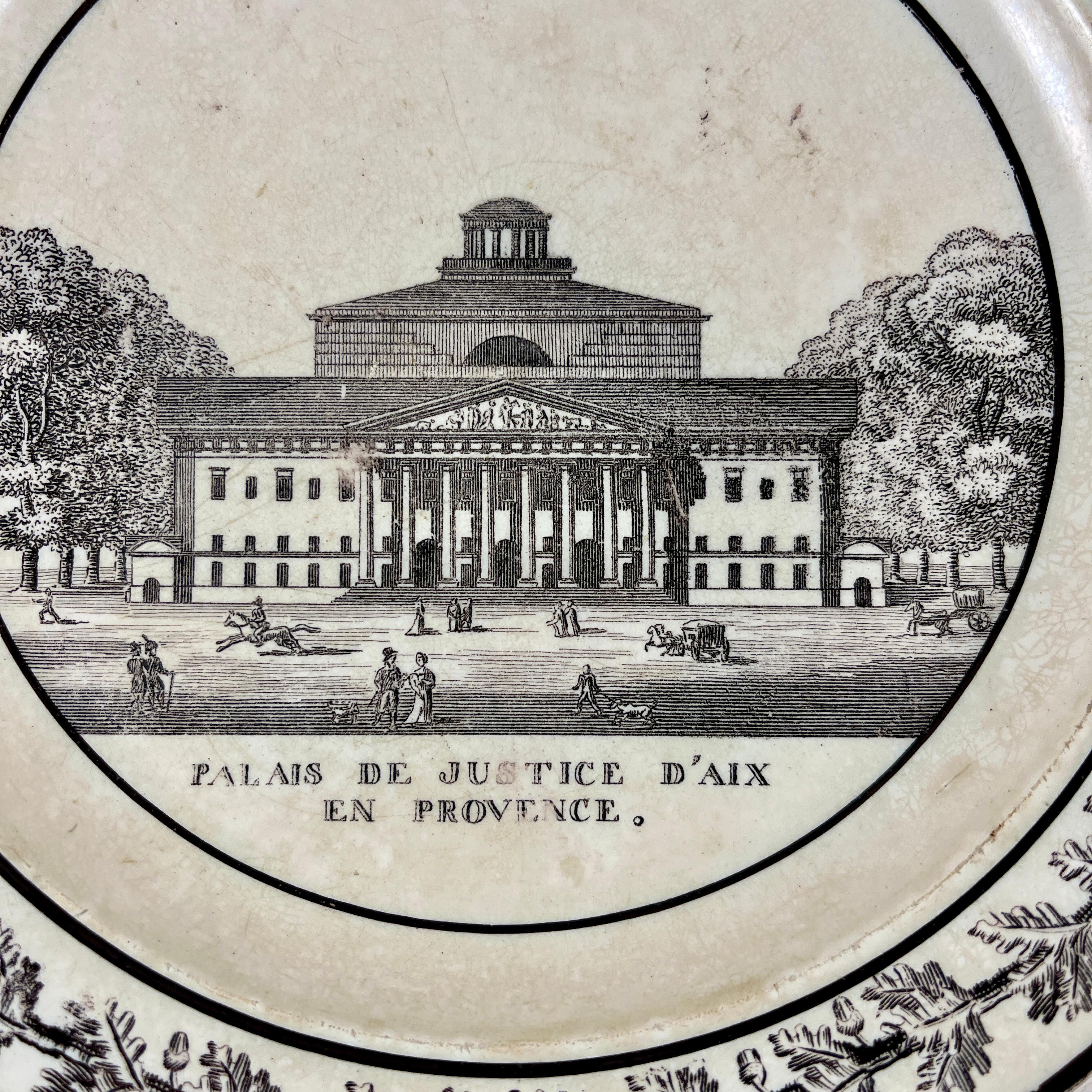 A French Neoclassical faïence transfer printed creamware plate produced by Montereau, Creil, circa 1824-1836.

A black transfer of an architectural image on a creamware body, depicting Le Palais De Justice d’Aix en Provence . The building is