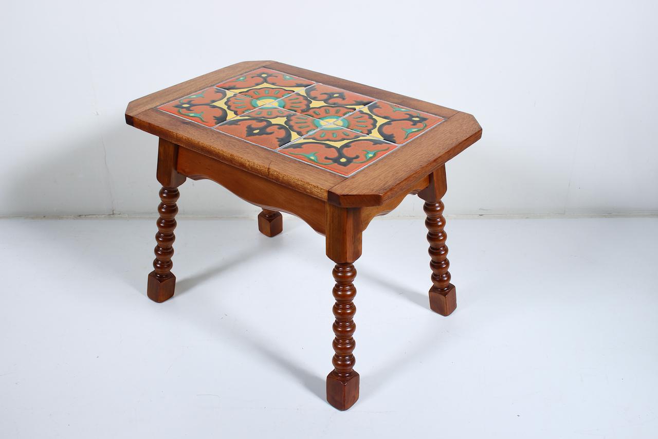 Rancho California Catalina Pottery, Taylor Tilery style Spanish tile top table. Featuring a sturdy, rectangular Walnut and Oak framework atop a smooth, balanced hand turned four legged Base, with 6 hand painted abstract floral motif squared glossy