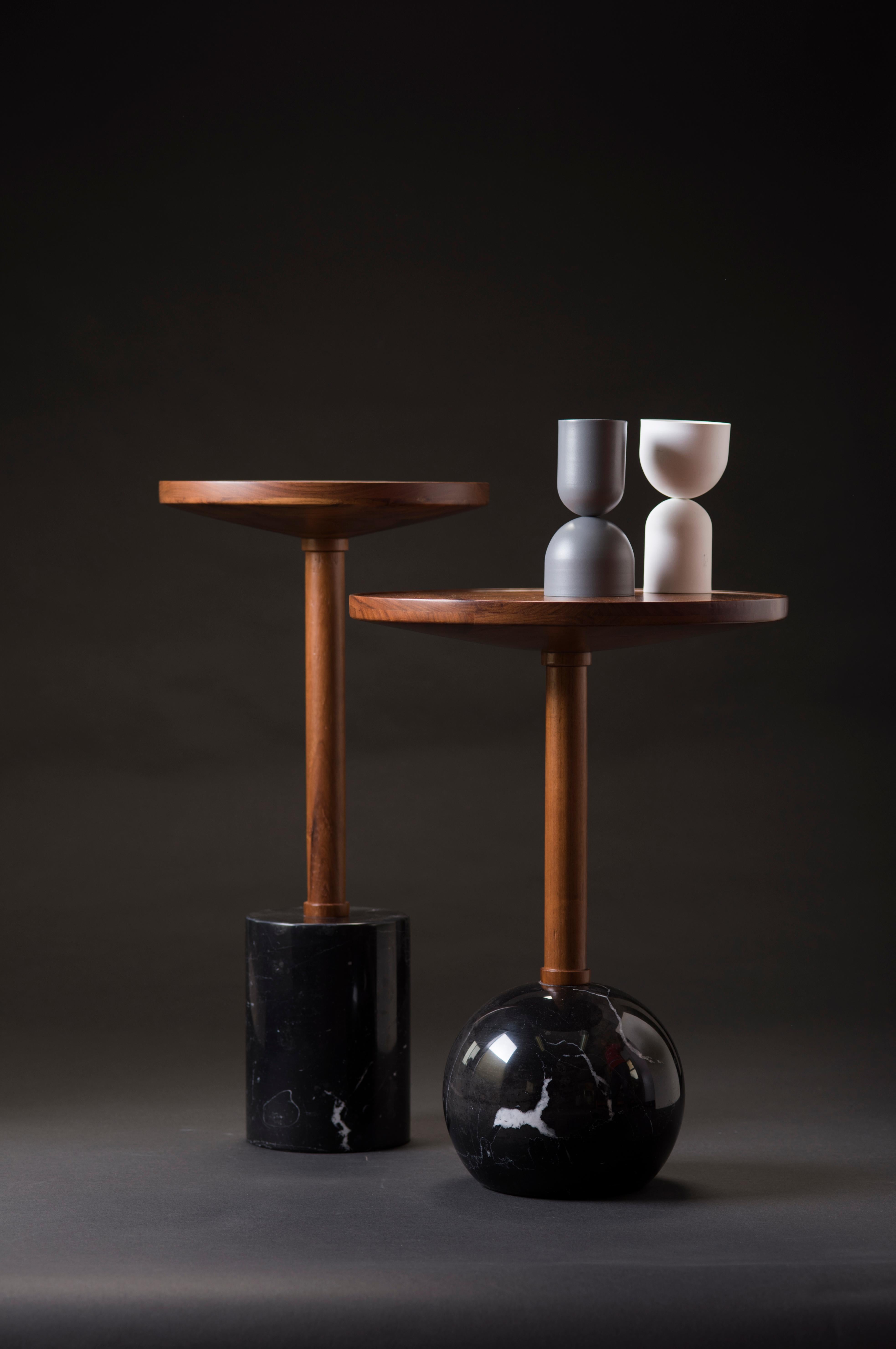 Honoring the process of craftsmanship, geometry makes poetry in the Mesas Monterrey. Both tables are turned by hand; the bases are made of a marble cylinder and sphere, the tops are made of solid tzalam wood in two different diameters. With
