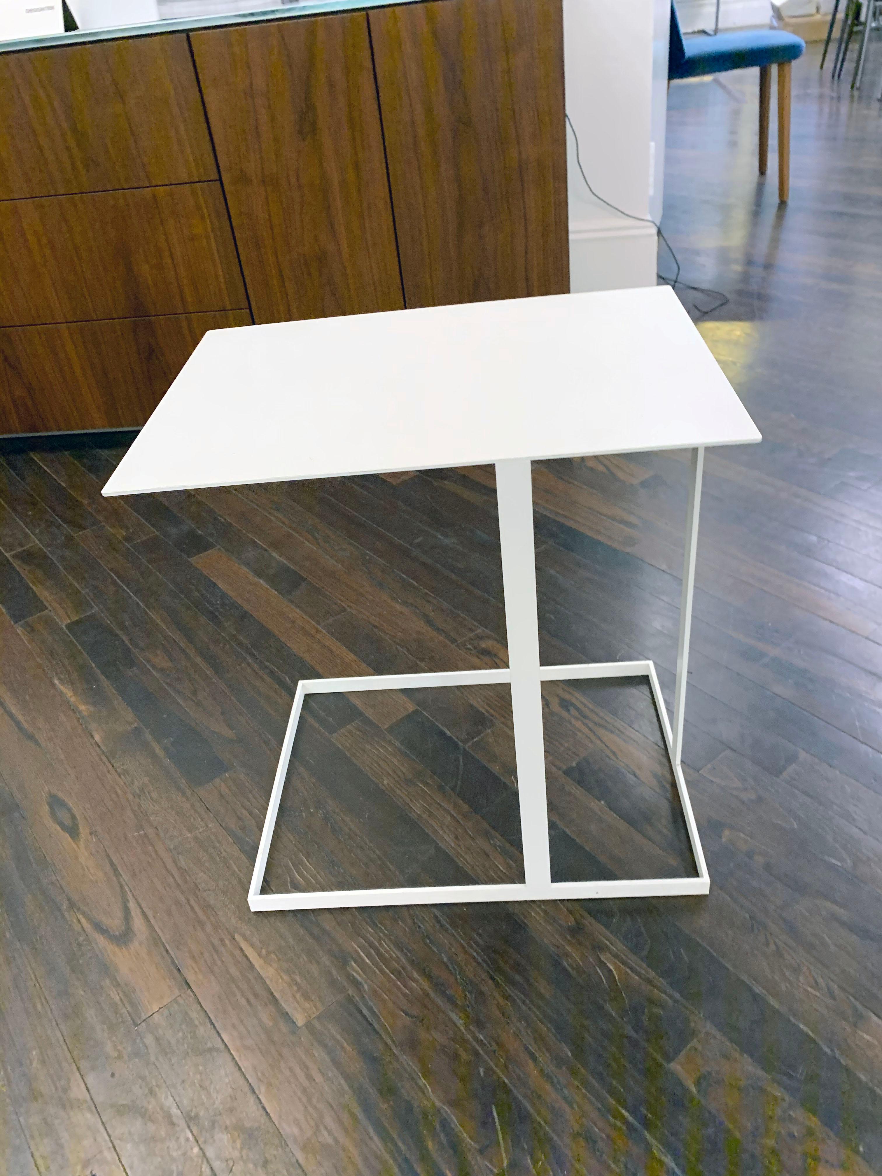 Annex is a multifunctional side table. The support has asymmetrical structures of flat metal strips. The functions of the free tabletop with projection are obvious and are ideal for working from the couch or lounge chair with a laptop, for putting