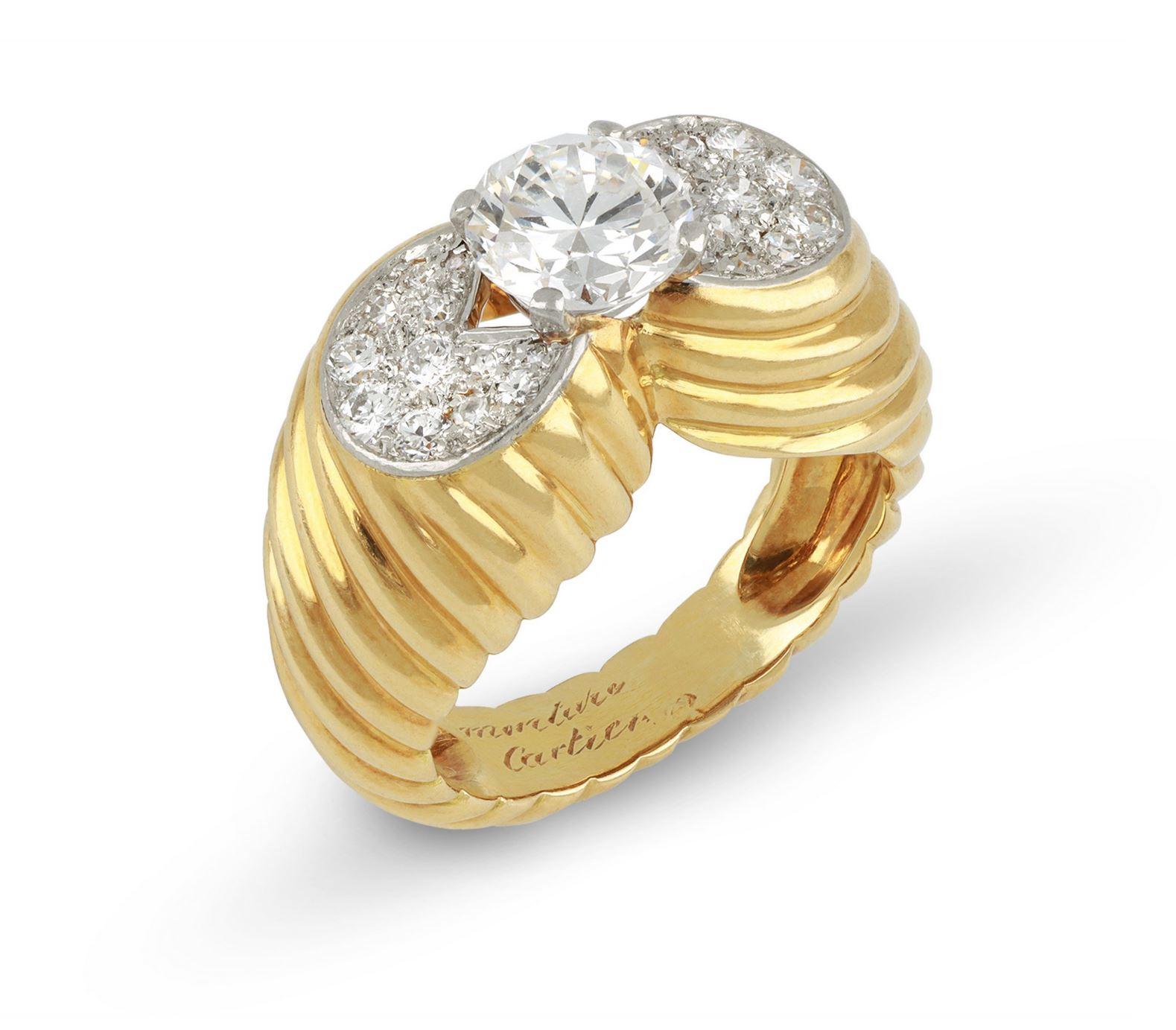 Monture Cartier diamond cocktail ring. Centrally set with a round old cut diamond in an open back claw setting with an approximate weight of 1.30 carats, flanked by sixteen round eight-cut diamonds in open back grain settings with a combined weight
