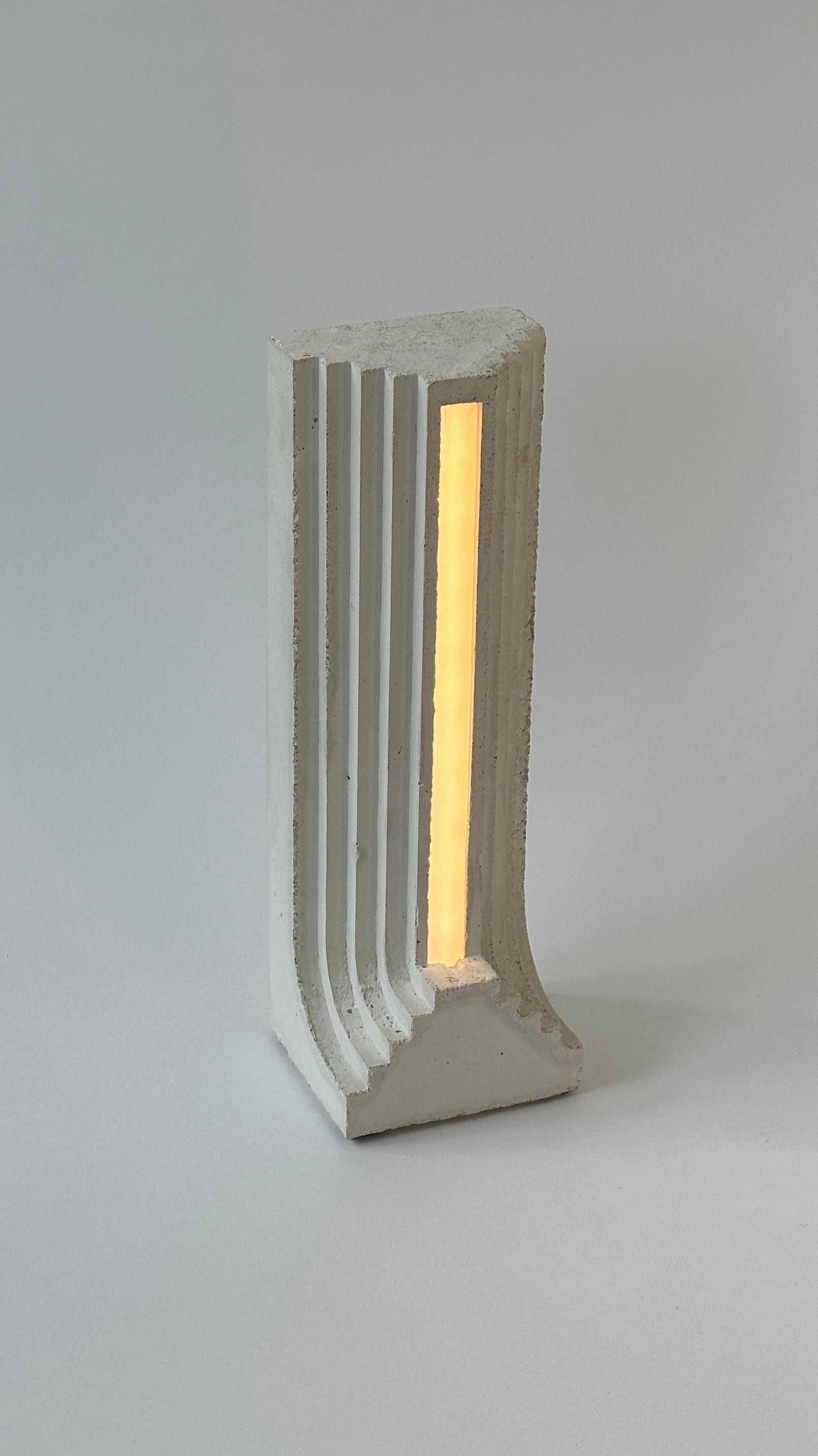 Monument Verso Table Lamp by Eingang Studio
Limited Edition.
Dimensions: D 10 x W 11 x H 30 cm.
Materials: Concrete and marble powder.
Weight: 2 kg.

LED 110-220V, variable light, EU or US plug.  Please contact us.

All our lamps can be wired