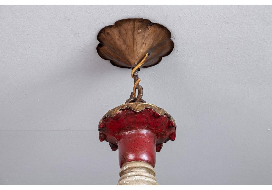 Un lampadario Florentine d'epoca, emozionante e molto decorativo, in condizioni originali. Con 12 bracci in metallo dorato che sorreggono finti portacandele gocciolanti e che circondano un imponente elemento centrale in legno tornito dipinto in