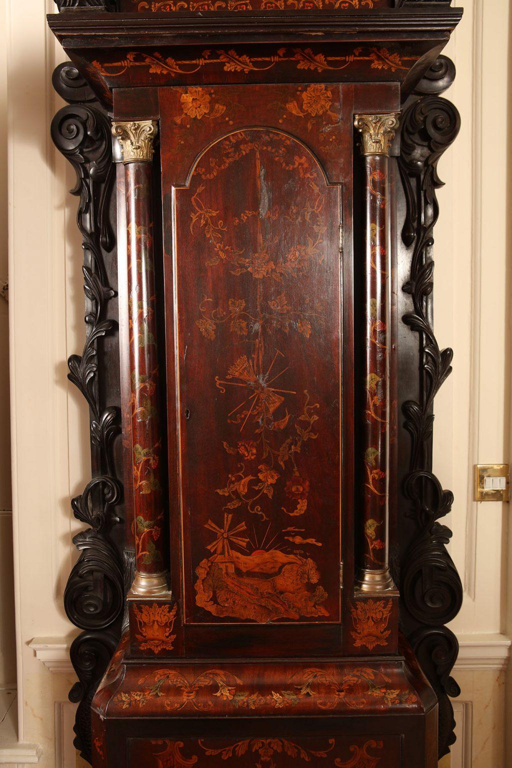 Early 20th-century longcase marquetry clock of exceptional proportions, the body of the clock with marquetry panels and flanked by richly carved side panels and raised on hairy paw feet.
Possibly Ireland, circa 1900
Measures: Height 3 meters
