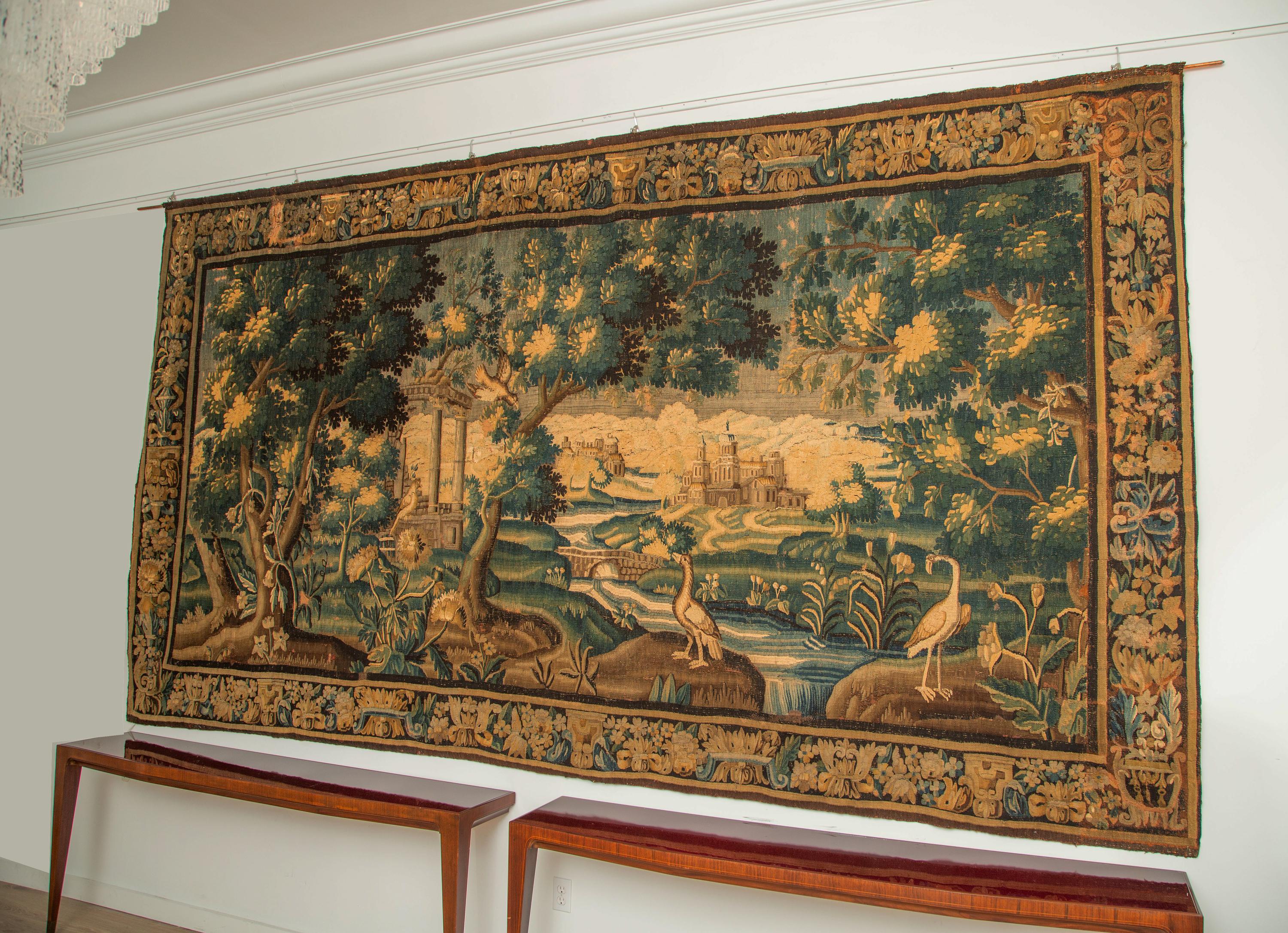Monumental wool tapestry verdure scenery with herons and fowl in a river landscape with a village in the distance. Lined and mounted with hanging loops. Great overall condition, vivid colors and great details.