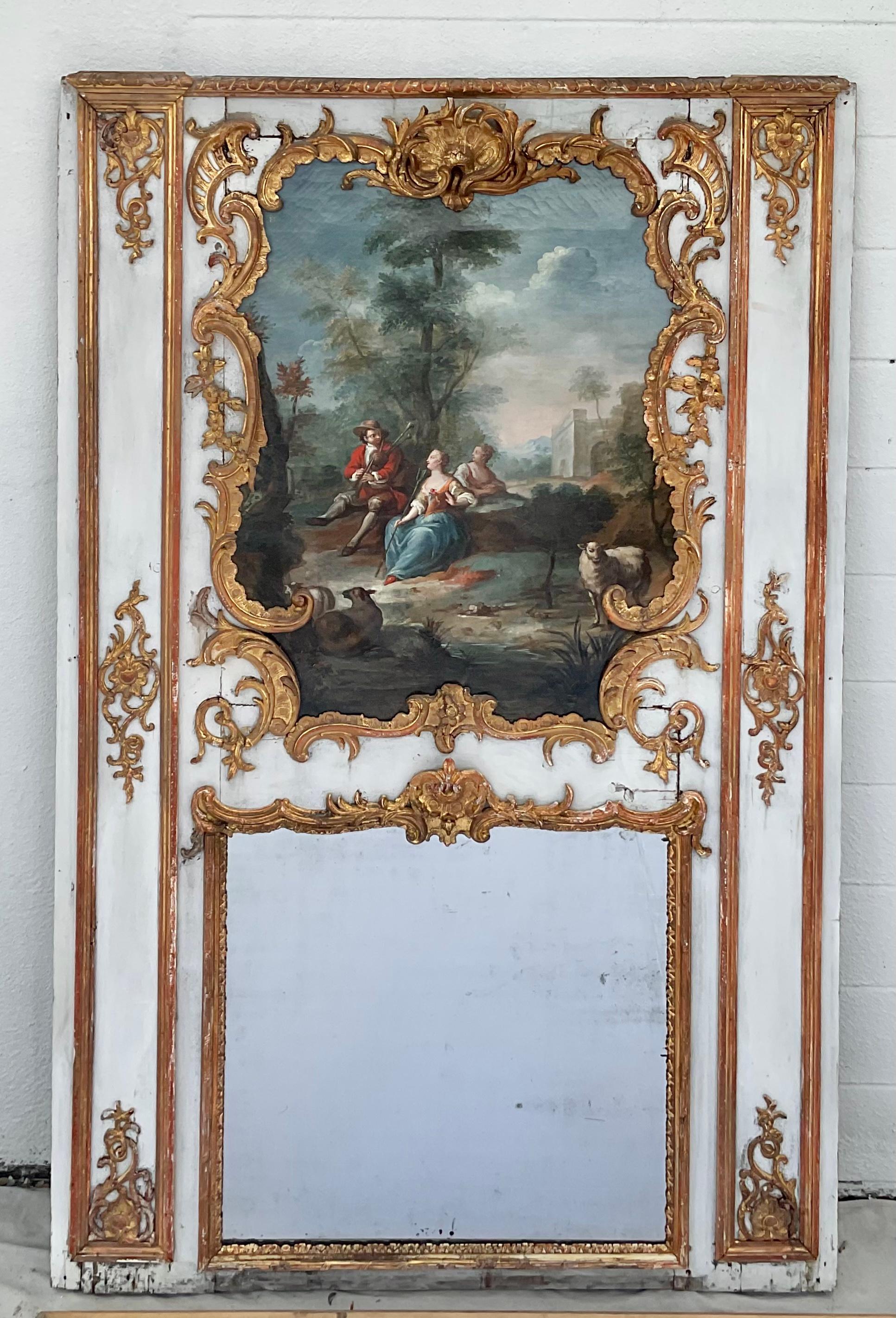 This is an absolutely magnificent 18th century French Louis XV Period Trumeau mirror. Featuring a distressed green painting frame, a finely carved gilt wood laurel leaf design all around, supporting a Baroque shell carving to the center just above