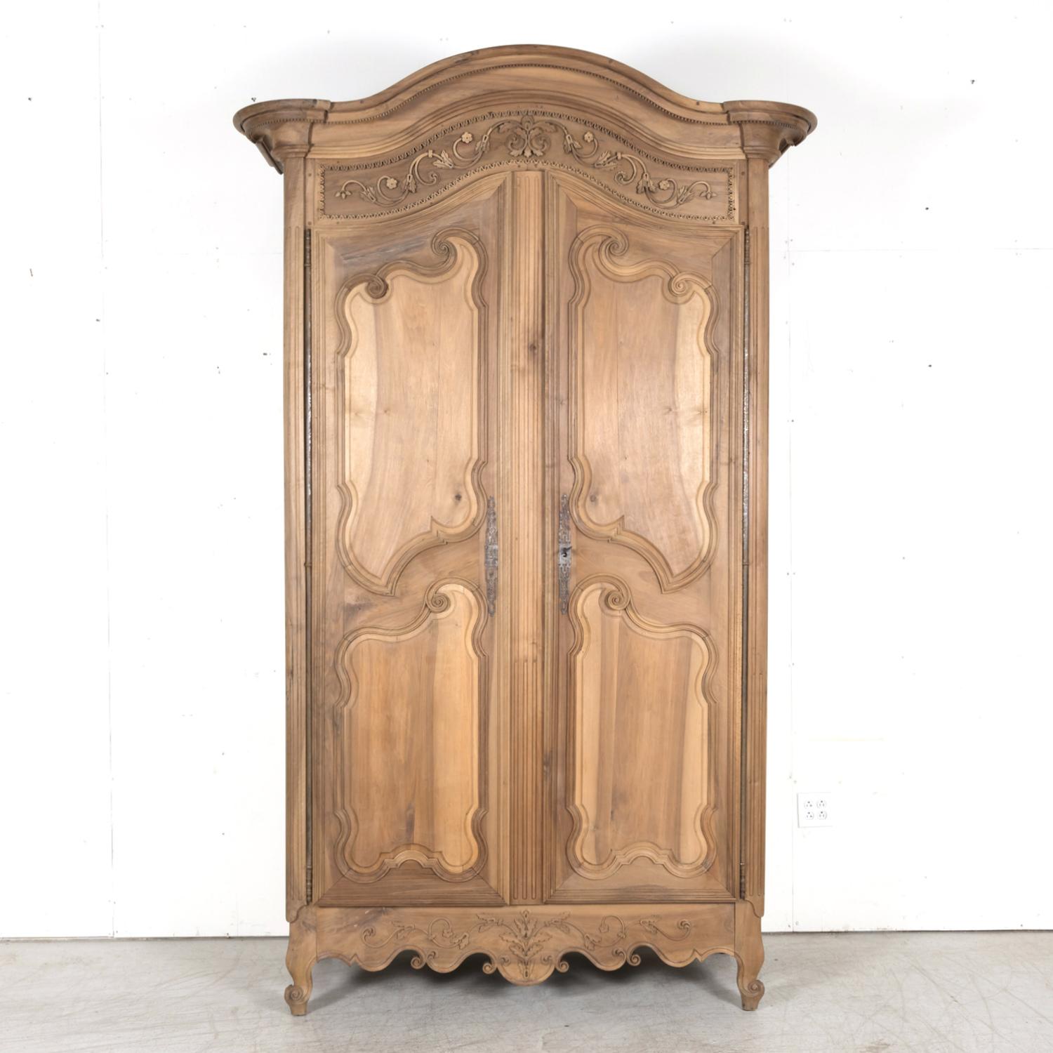 Exceptionnelle armoire française d'époque Louis XV du XVIIIe siècle, vers les années 1750, fabriquée à la main en noyer massif par de talentueux artisans de Lyon, la capitale de la région Auvergne-Rhône-Alpes, mondialement réputée pour sa production