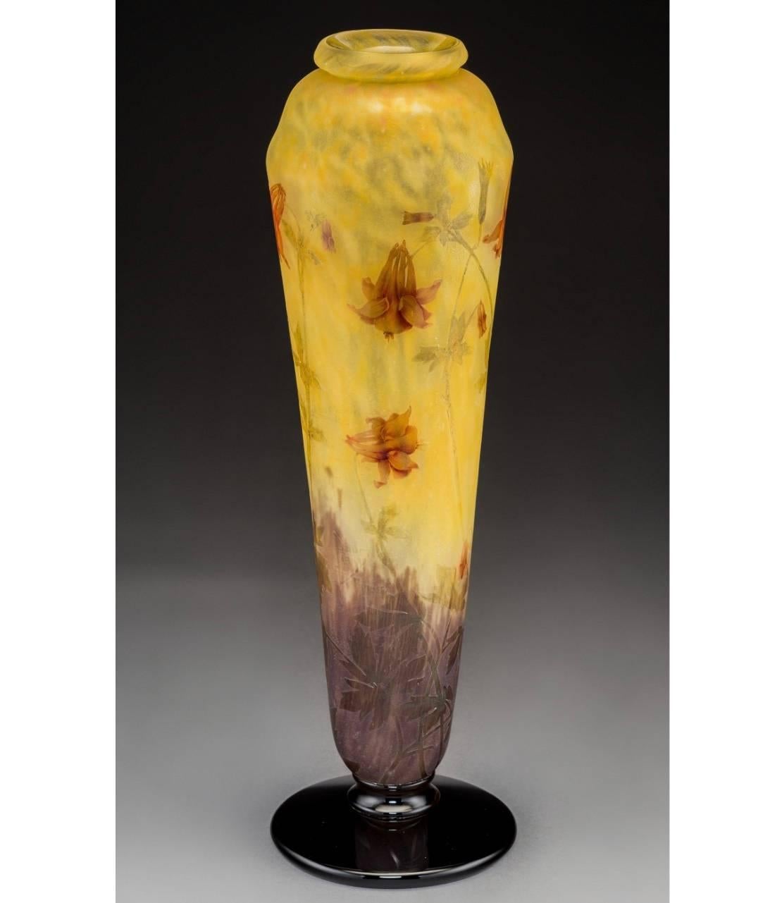 Large enameled glass columbine flower pedestaled vase by Daum nancy. Variegated yellow glass with enameled red flowers, circa 1900. 

Signed in cameo daum nancy with cross of lorraine 

Height: 18-3/4 Inches.

Provenance: Heritage Auctions, Sale