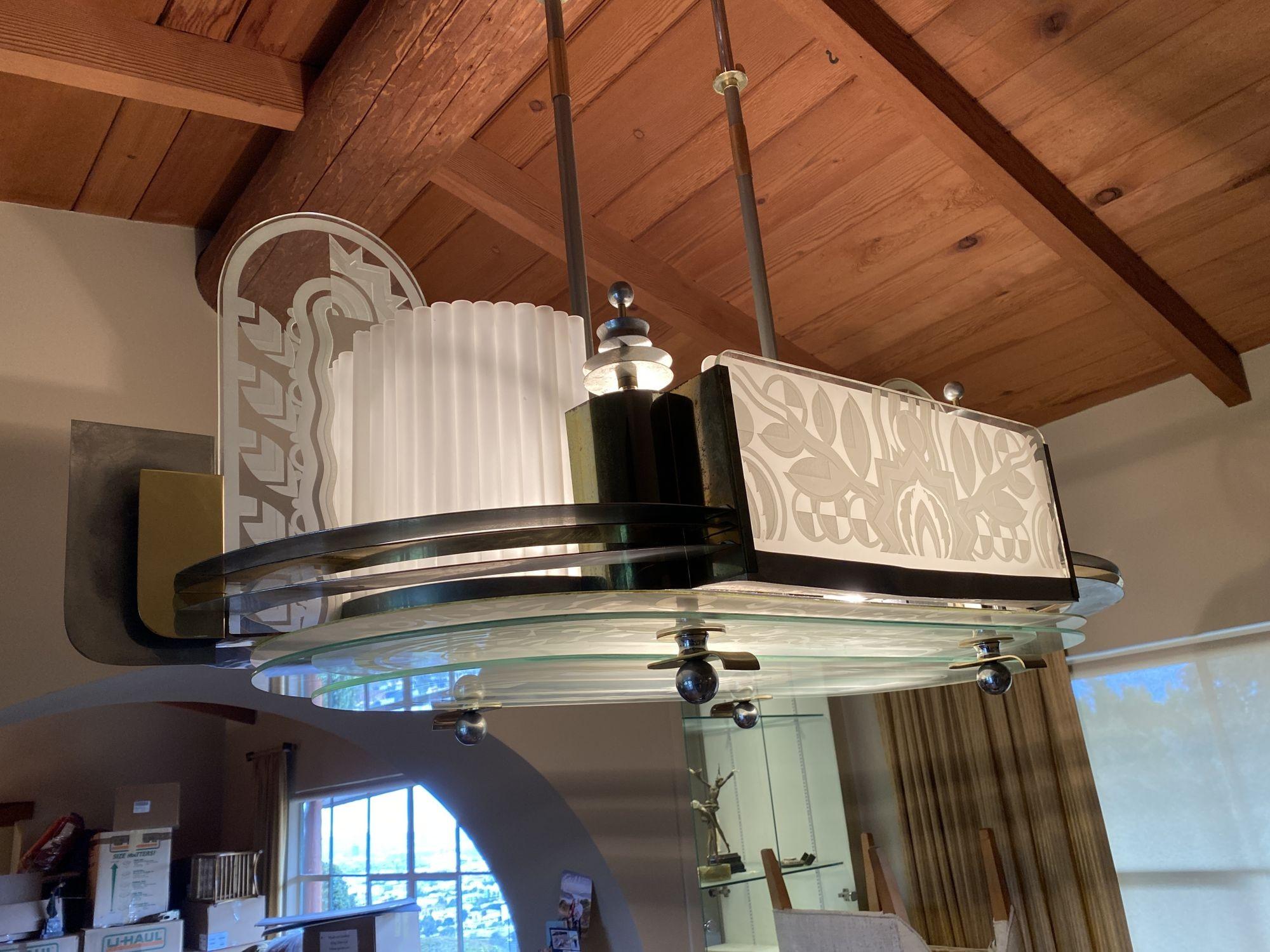 Original 1931 Art Deco cut and blasted glass and chrome steel geometric chandelier with highlights of Brass that was taken from the exclusive basement lounge of the famous Wiltern Theater in Los Angeles during renovations in 1985. 
 
The