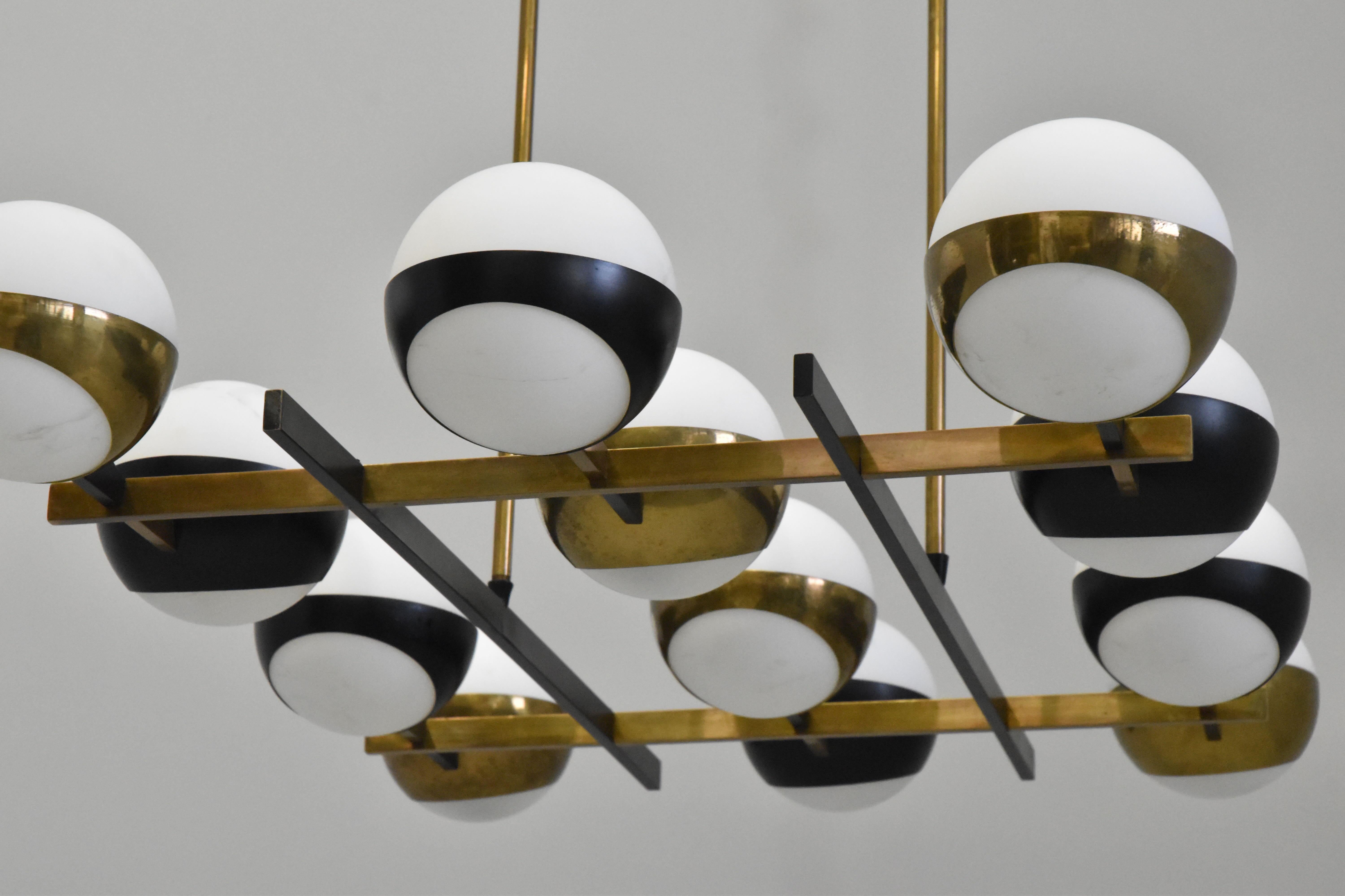Monumental 1950s 12-Globe Glass & Metal Chandelier for Stilnovo.
 
Executed in 12 opaline glass globes, brass and black enameled metal. An iconic Italian light sculpture of impressive scale and incomparable refinement. Sourced from an estate in