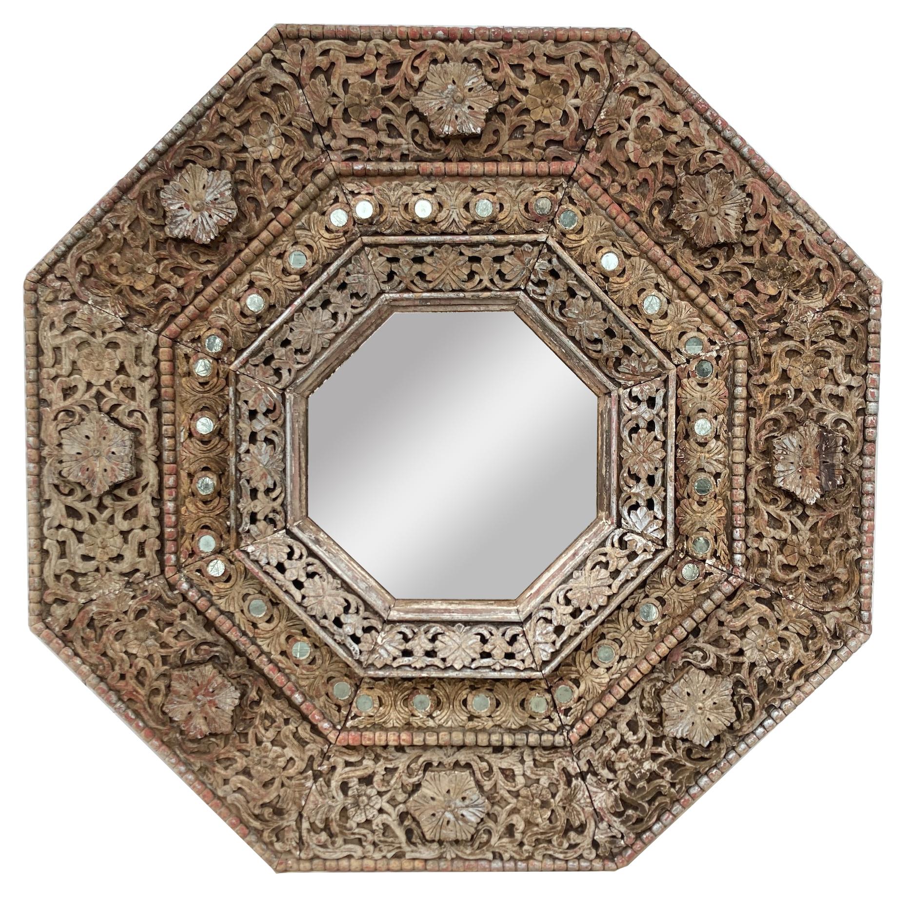 Monumental 1950's Carved Indian octagonal mirror. At 5 1/2 feet by 5 1/2 feet, this mirror is a true statement piece. The deep carving gives it a
feeling of folk art, while the weathered sumace and the carved motifs make the piece exotic.
We see