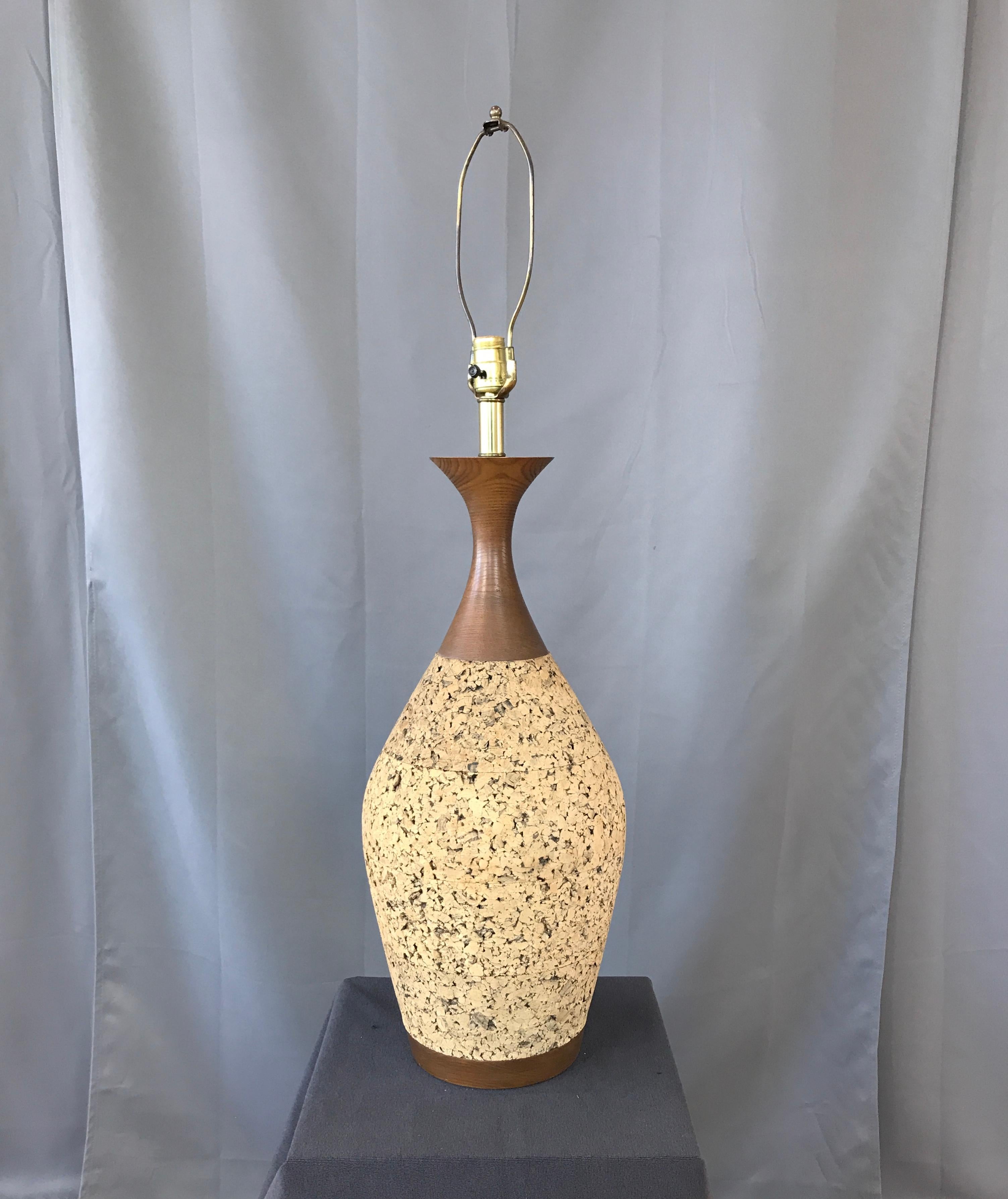 Monumental 1970s cork table lamp. Curvy walnut stain neck, and base, with a huge cork body in-between. With its original large lamp shade that's in wonderful condition.

Measurement below is to the top of its shade.
30 1/4 inches to top of its