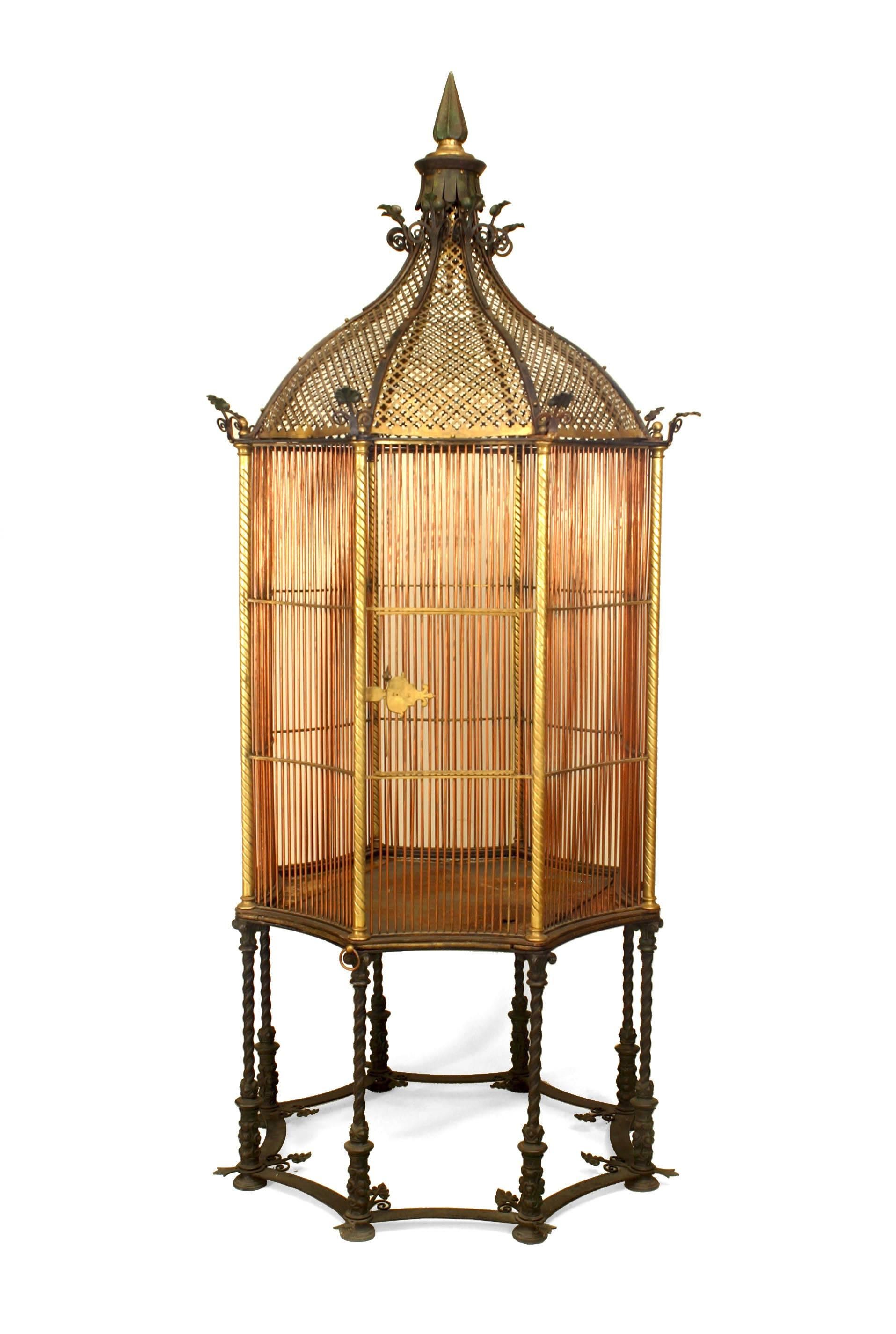 English Victorian bronze and copper octagonal shaped monumental bird cage with a gilt pierced dome & finial top raised on 8 swirl iron legs. (Patent #1107831-Henry Jones)
