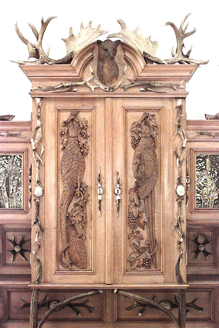 Rustic German (19th Century) oak hutch cabinet with horn trim and upper section with 2 doors with carved birds & 2 small doors with leaded glass and 2 carved doors on base.
