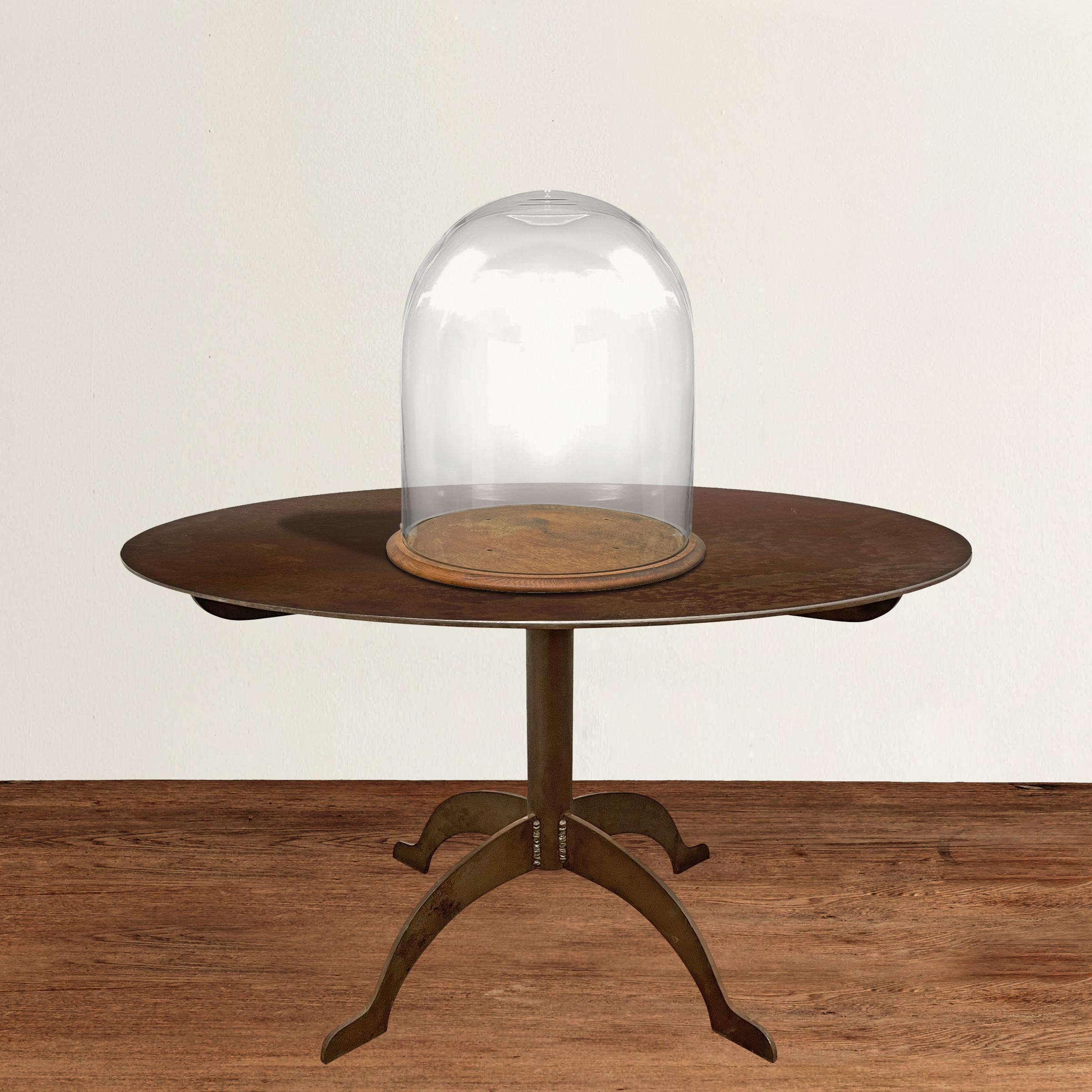 An incredible and monumental 19th century American glass cloche with a wooden platform raised on bun feet, and just waiting for you turn it into your very own cabinets of curiosities.