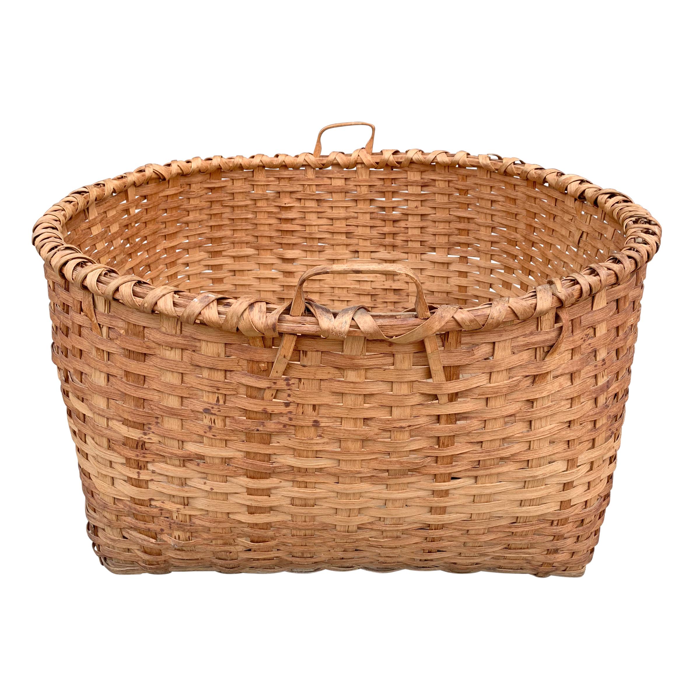 An incredible monumental 19th century American oak splint basket of square form at the bottom turning into a circular form at the top, with a double-banded rim, and two bentwood handles. Probably originated in upstate New York.