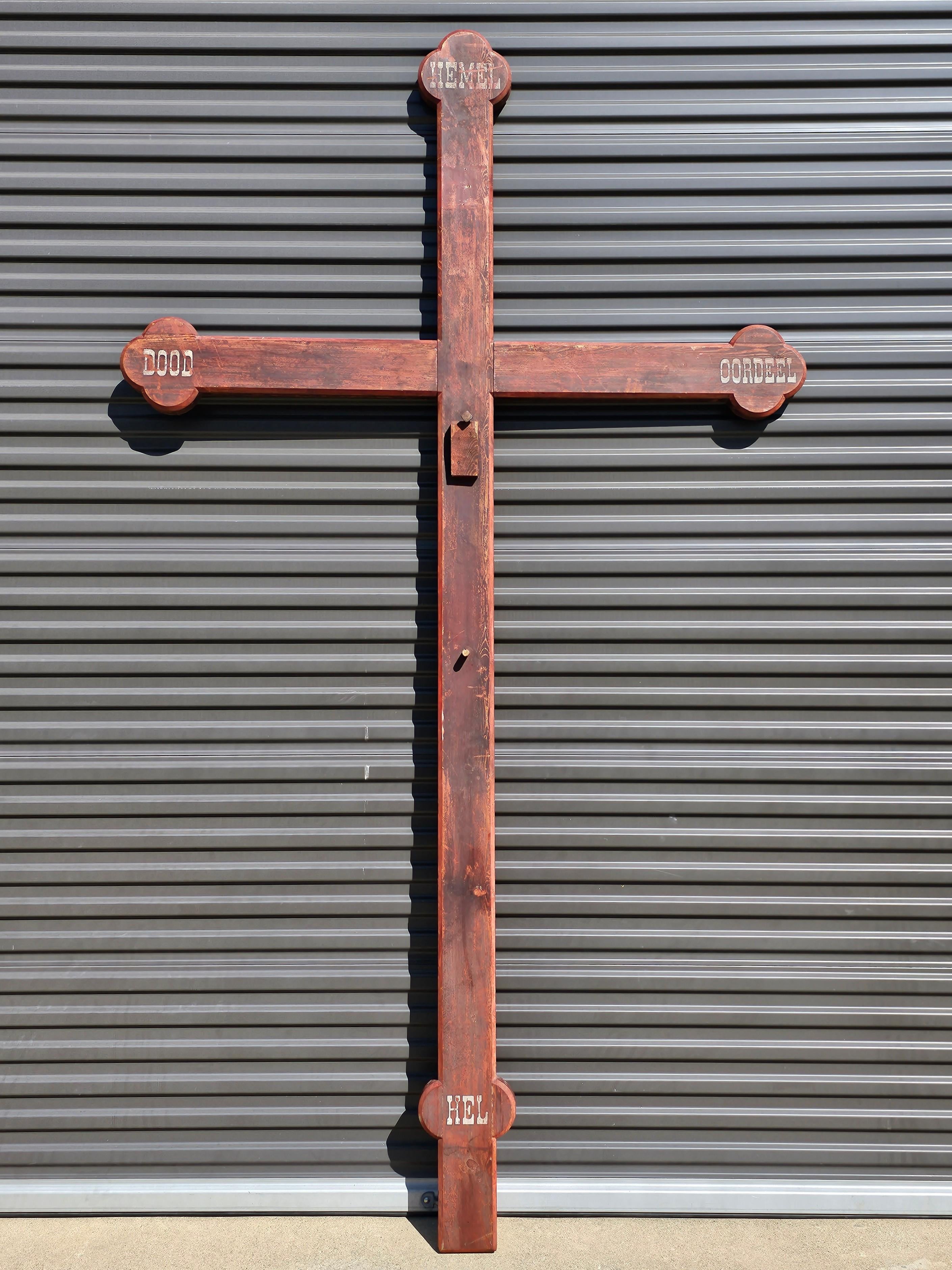 A massive nearly 10 foot tall by 5.5 foot wide antique Dutch ecclesiastical wooden cross.

Hand-crafted in the Netherlands in the 19th century, very large sculptural Celtic cross form, originally mounted as a crucifix, featuring the original red