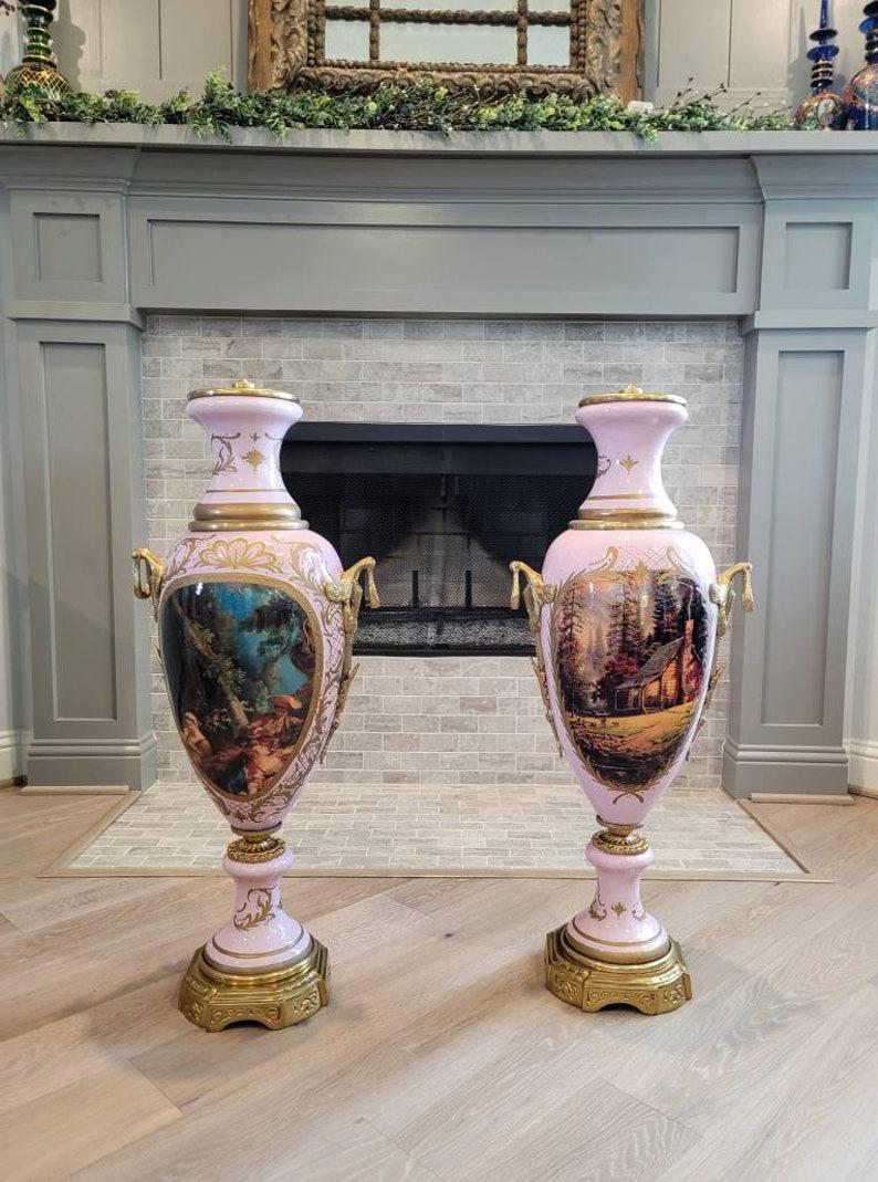 A magnificent pair of French antique gilt bronze mounted pink Sèvres porcelain style vasiform urns.

Born in France in the 19th century, hand-crafted in rich grandiose Empire taste, palatial awe-inspiring large scale, featuring ornate finely