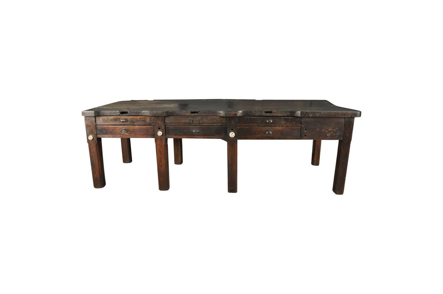 A fantastic and monumental later 19th century French jeweler's worktable. Soundly constructed in richly stained beech and pine woods. This piece serves as a fabulous kitchen island or bar table. Terrific charm and character.