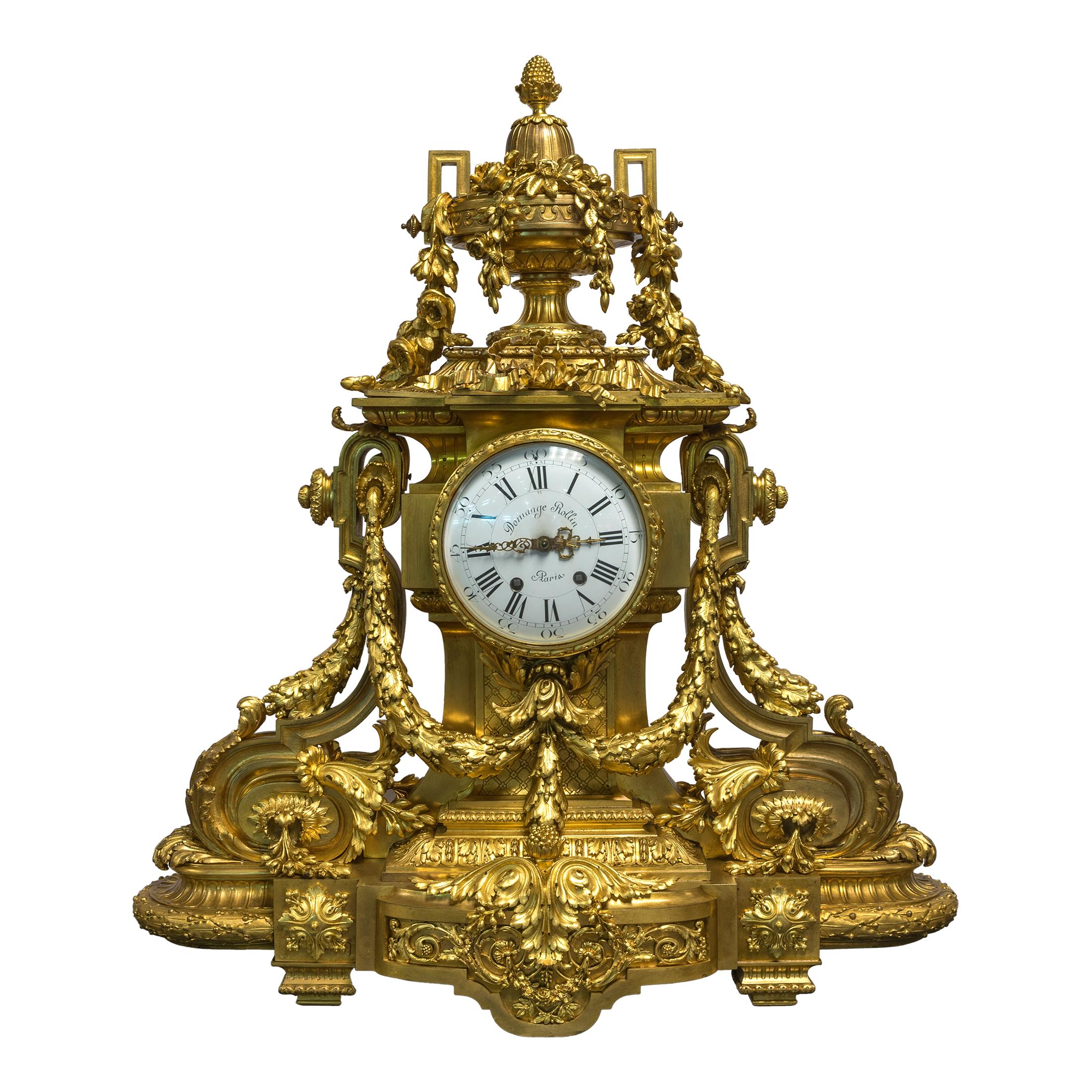 A fine quality monumental gilt bronze three-piece clock garniture.
Comprising a fine quality large gilt bronze eight-arm figural rococo candelabra and a mantel clock, the black and white enameled dial inscribed Domange Rollin Paris. 

Origin: