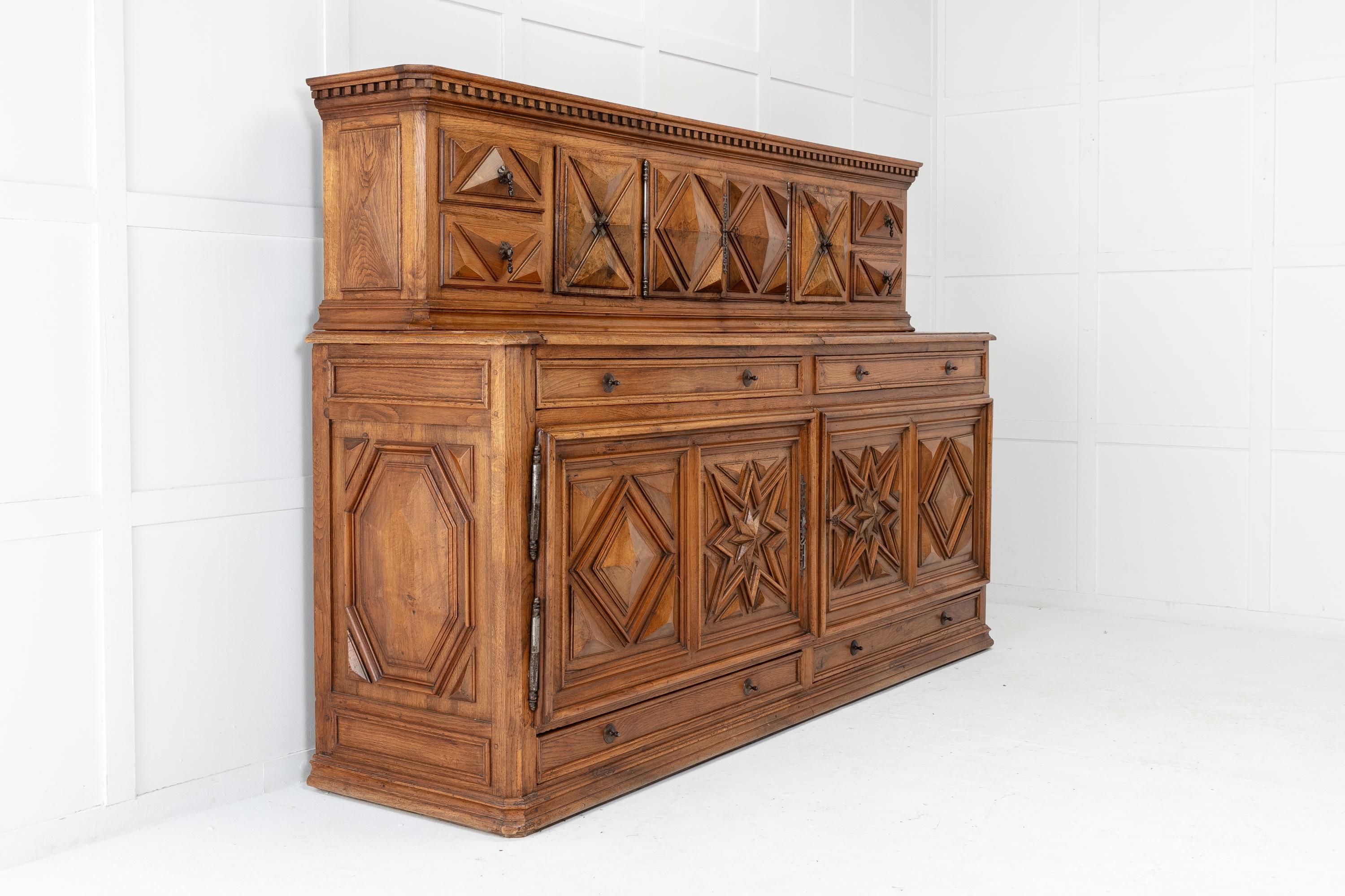 Fabulous, monumental scale 19th century French walnut and oak buffet. The top has a dentil moulded cornice with cupboards and drawers below having extensively raised carvings and original metalwork. Across the top half of the buffet is an