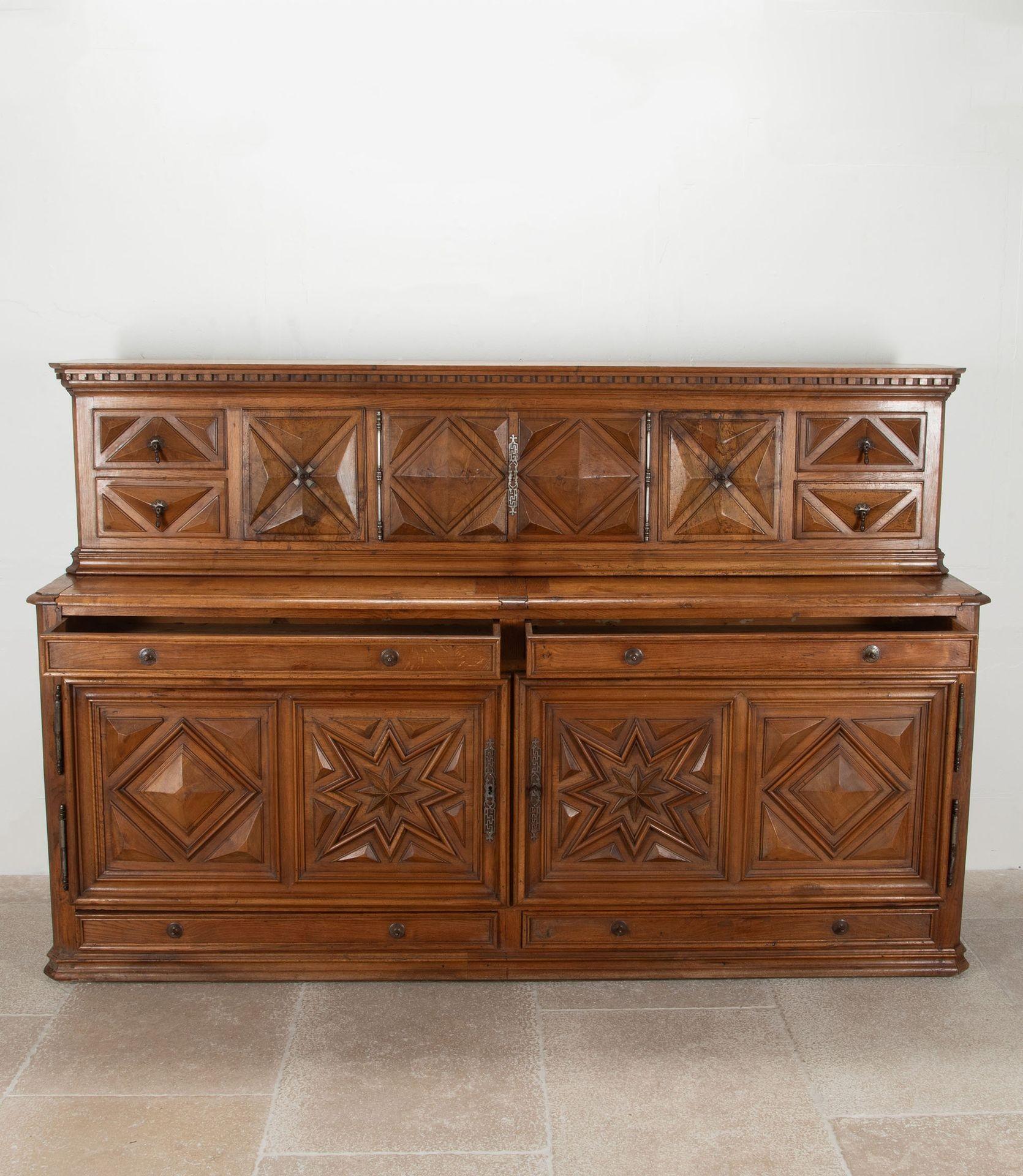 Fabulous, monumental scale 19th Century French walnut and oak buffet. Circa 1840.
The top has a dentil moulded cornice with cupboards and drawers below having extensively raised carvings and original metalwork. Across the top half of the buffet is