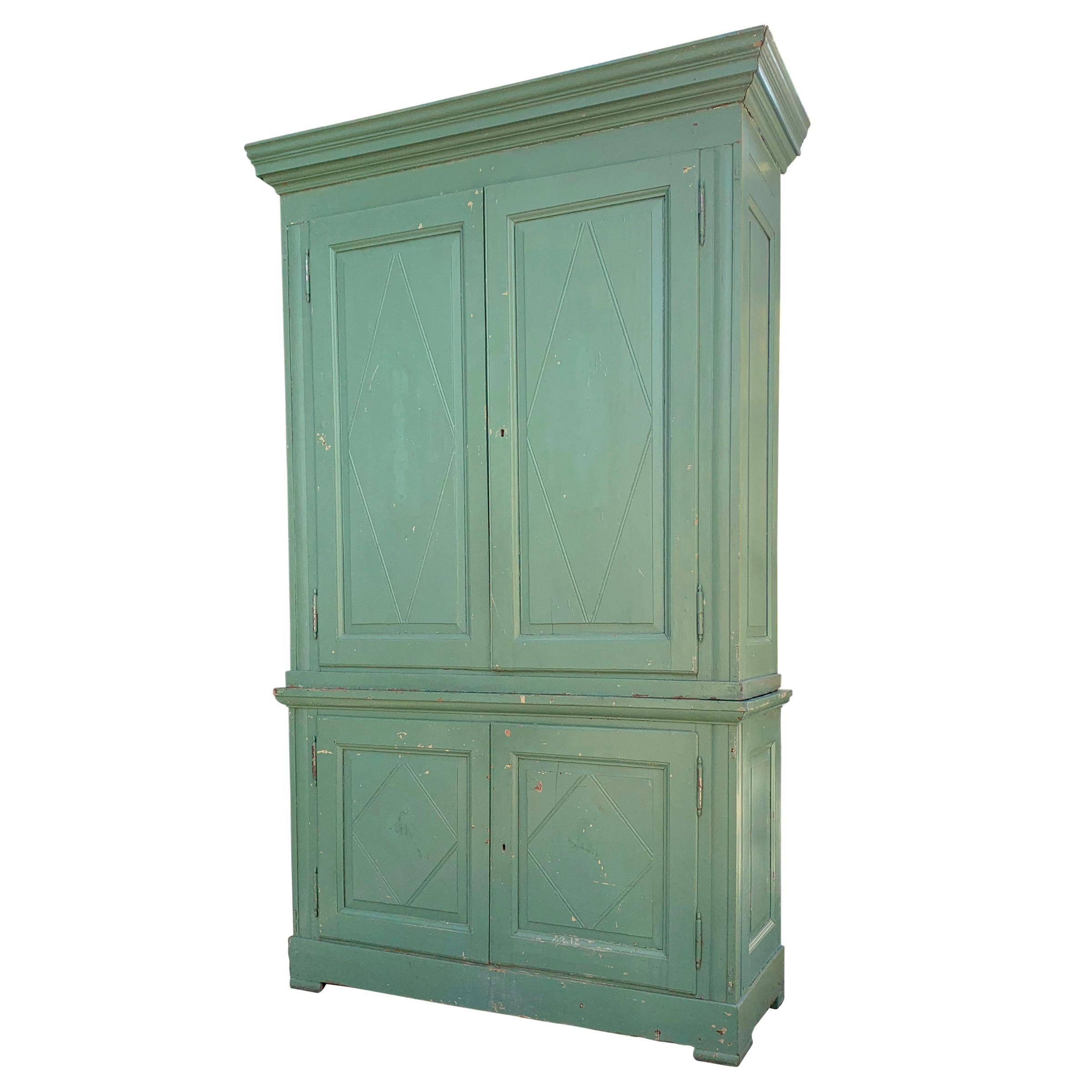 A dazzling monumental 19th century Italian pistachio green painted pine cabinet with two large doors at the top and two smaller doors at the bottom, all with diamond paneling.