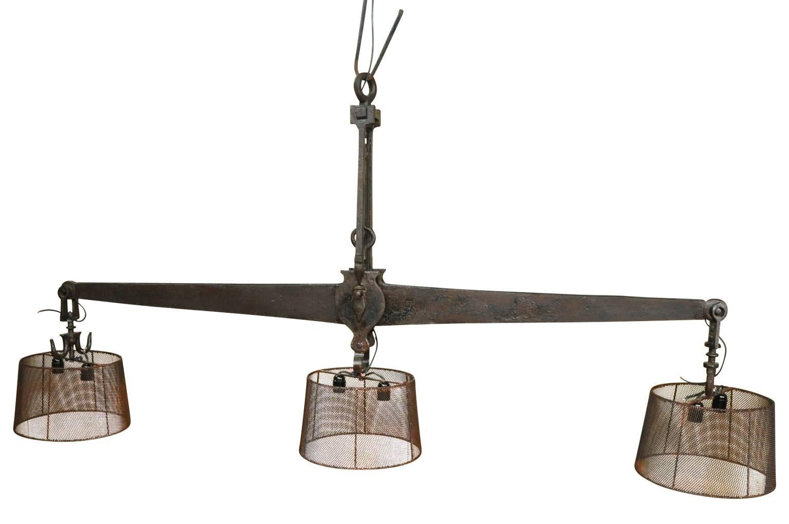 A monumental 19th century iron butcher's scale - now as a chandelier. A fantastic statement piece over a large kitchen island or in a great room. Inscribed with Barcelona Ano, 1875.