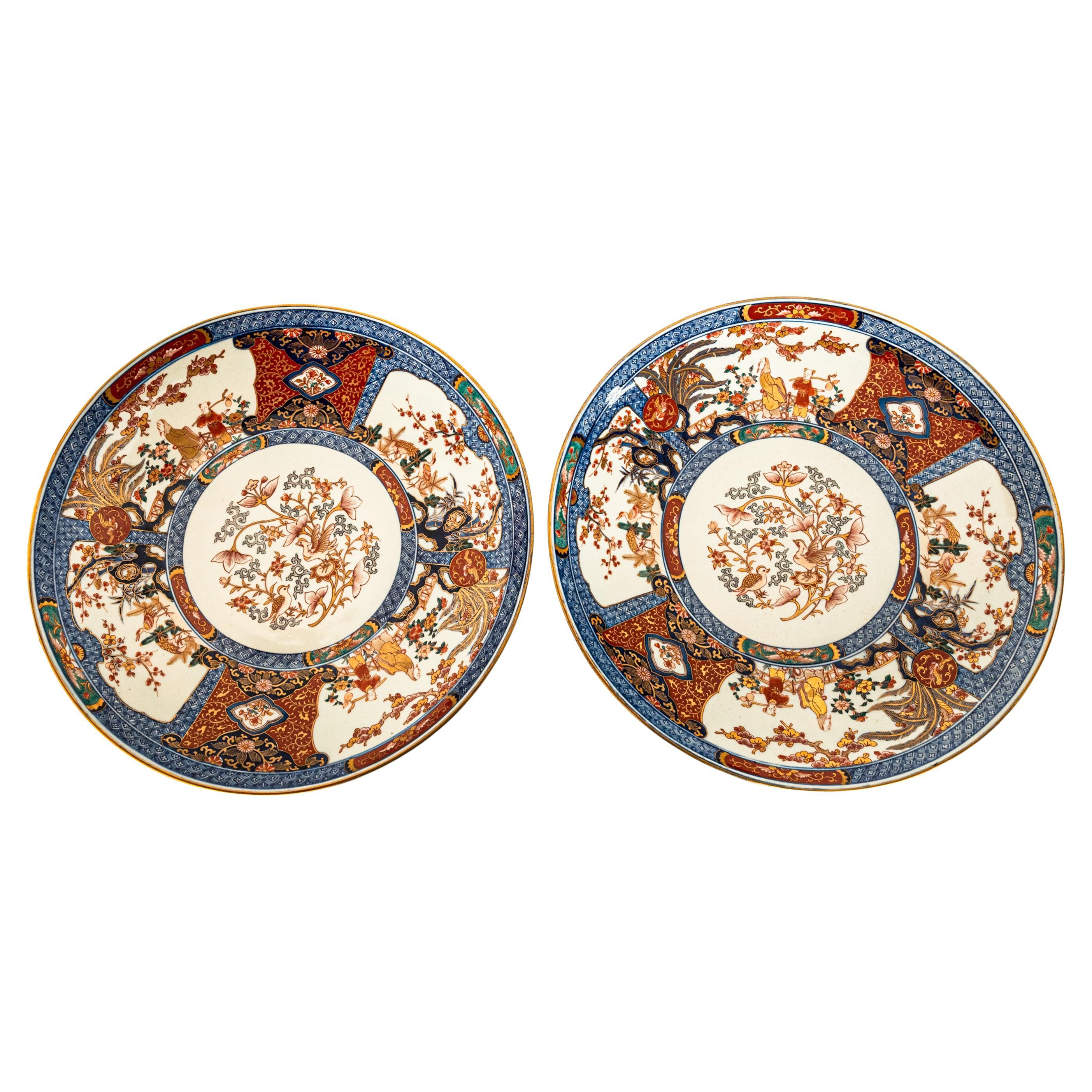 Exceptionnelle et monumentale paire d'assiettes en porcelaine japonaise de la période Meiji, vers 1880.
Chaque chargeur est finement et somptueusement décoré à la main de panneaux d'oxyde de fer bleu et rouge sous glaçure, rehaussés de décorations