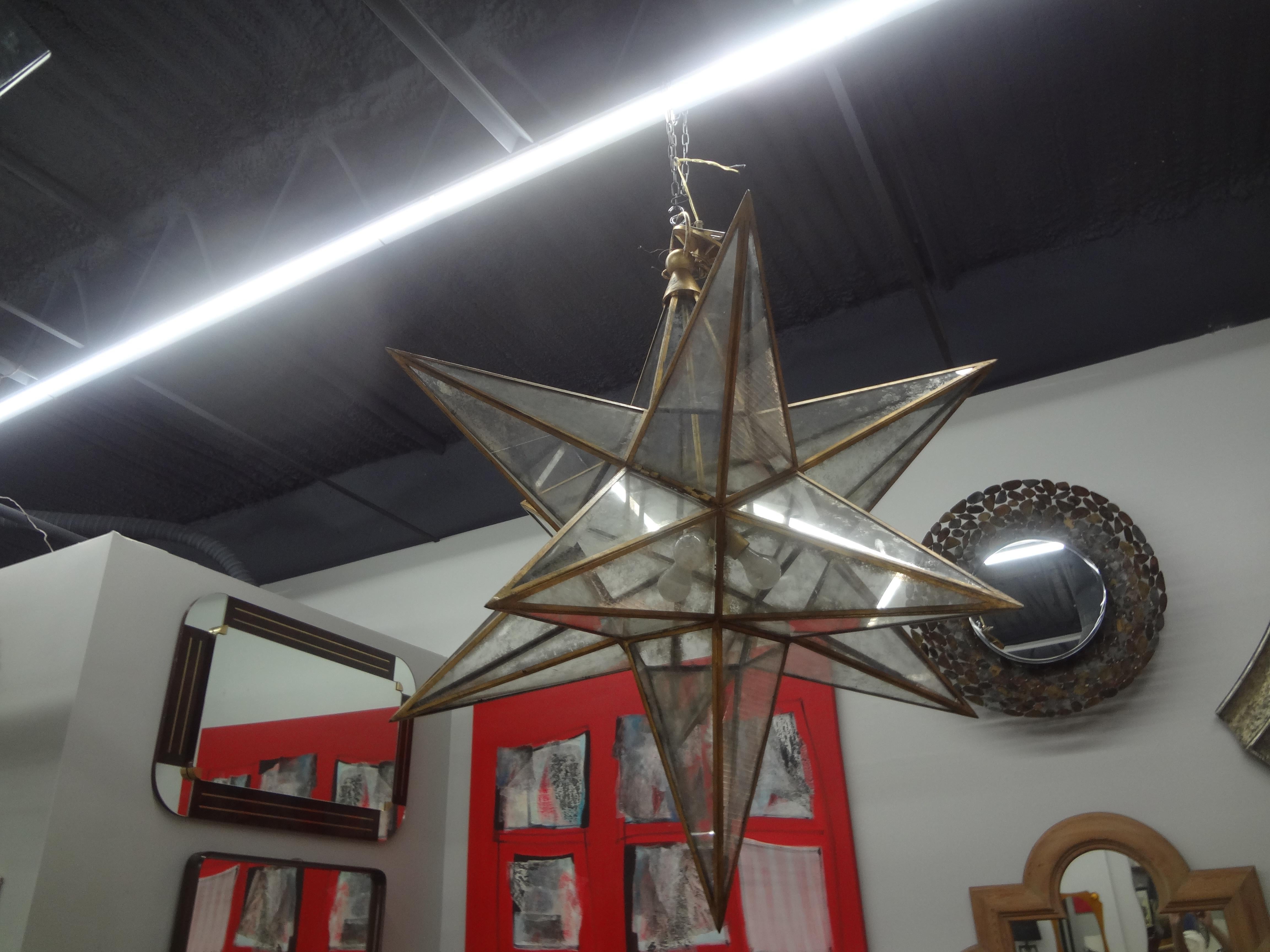 Monumental 52 Inch Star Shaped Chandelier.
This outstanding 20th century star shaped chandelier, possibly Italian is made of gilt metal with lightly mirrored panels. It retains the original canopy and chain. Dimensions given are excluding the chain