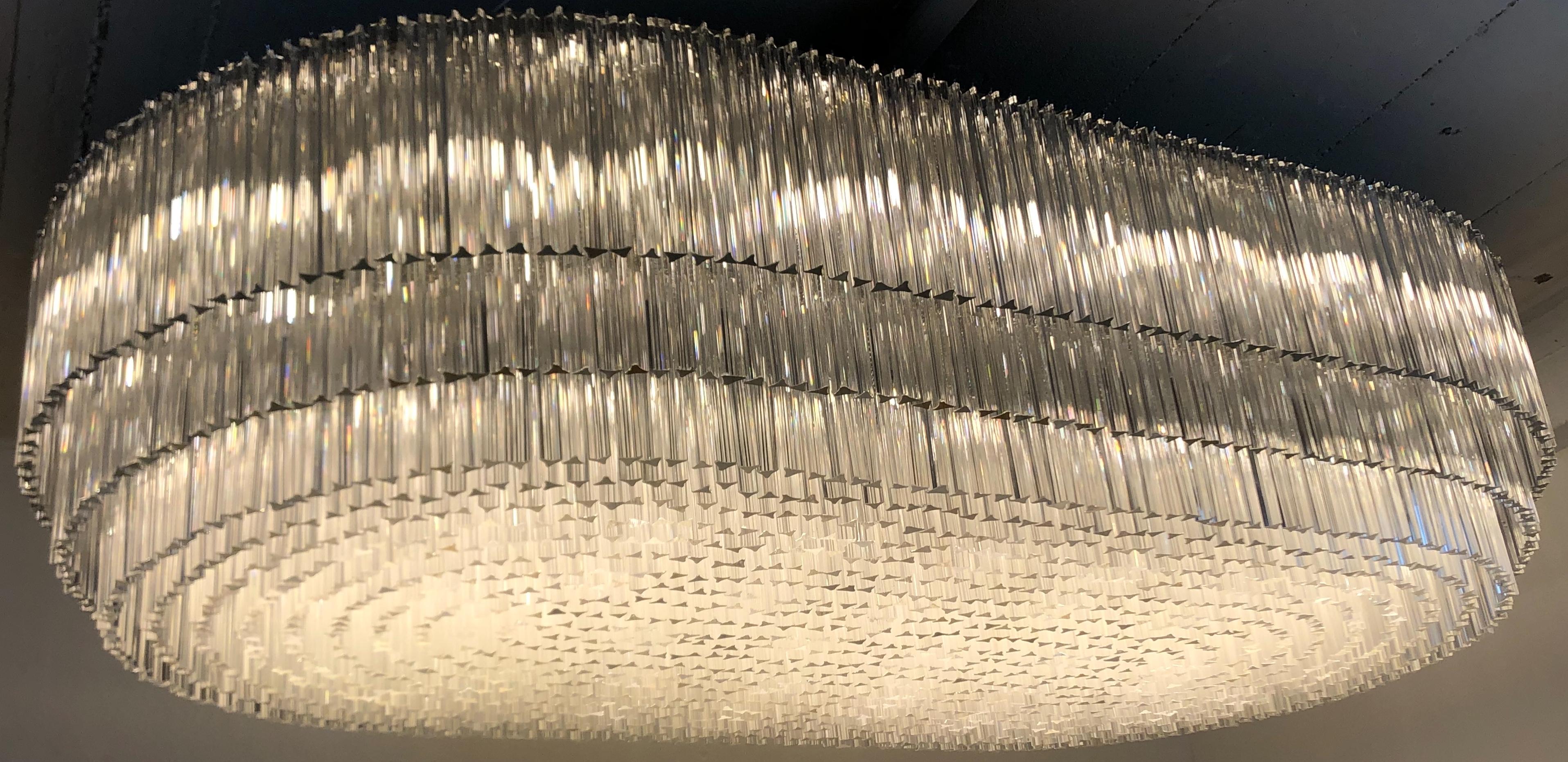 Étonnant lustre monumental en verre ovale de soixante-dix lumières, datant du milieu du siècle dernier, avec 1935 tiges en verre transparent de Murano, de quatre tailles différentes.
Le cadre se compose de deux parties qui sont vissées l'une à