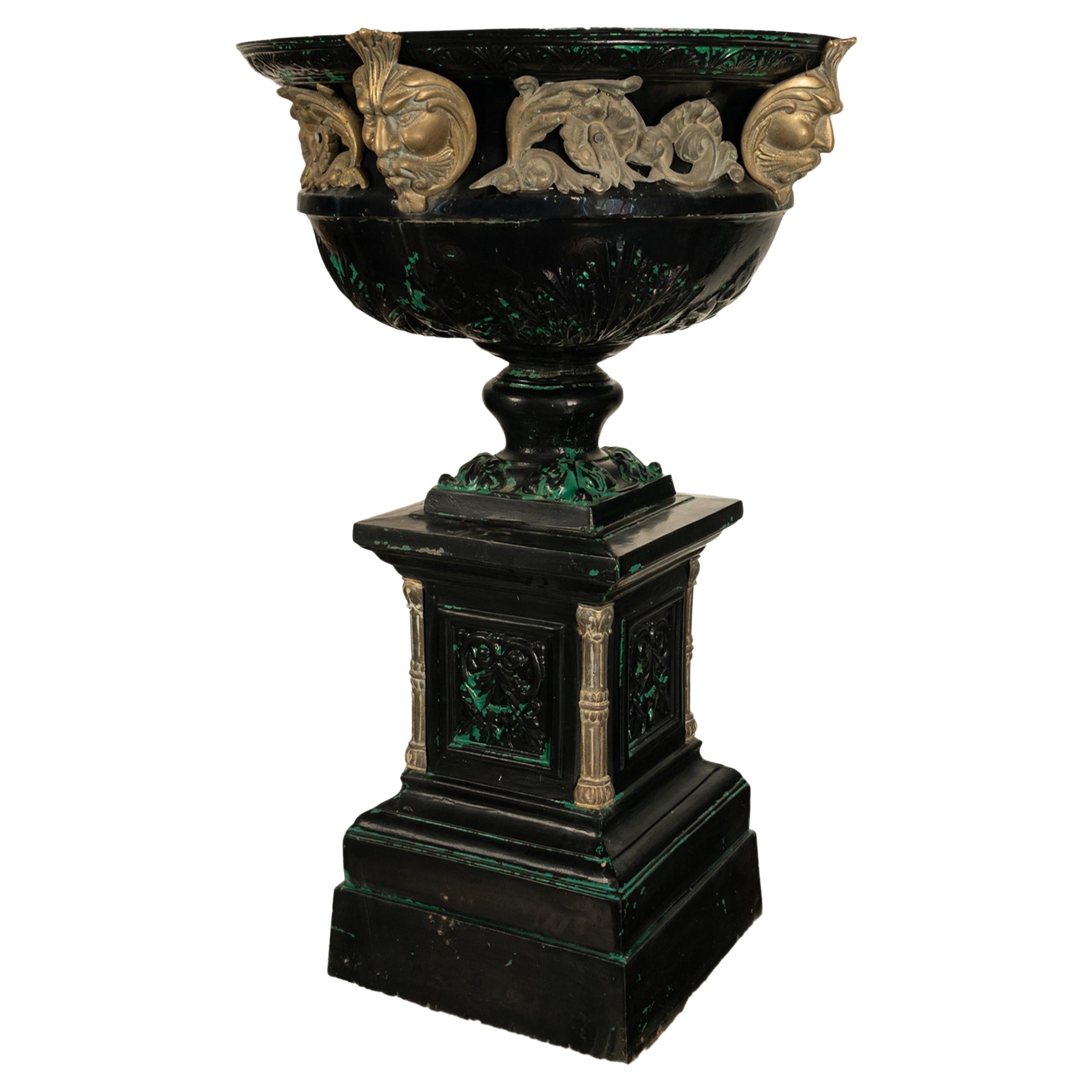 Une bonne urne de jardin monumentale en métal moulé sur piédestal vers 1930.
L'urne et le piédestal sont en deux parties, avec une urne circulaire de taille monumentale reposant sur un socle carré. L'urne est décorée au sommet d'un bandeau de