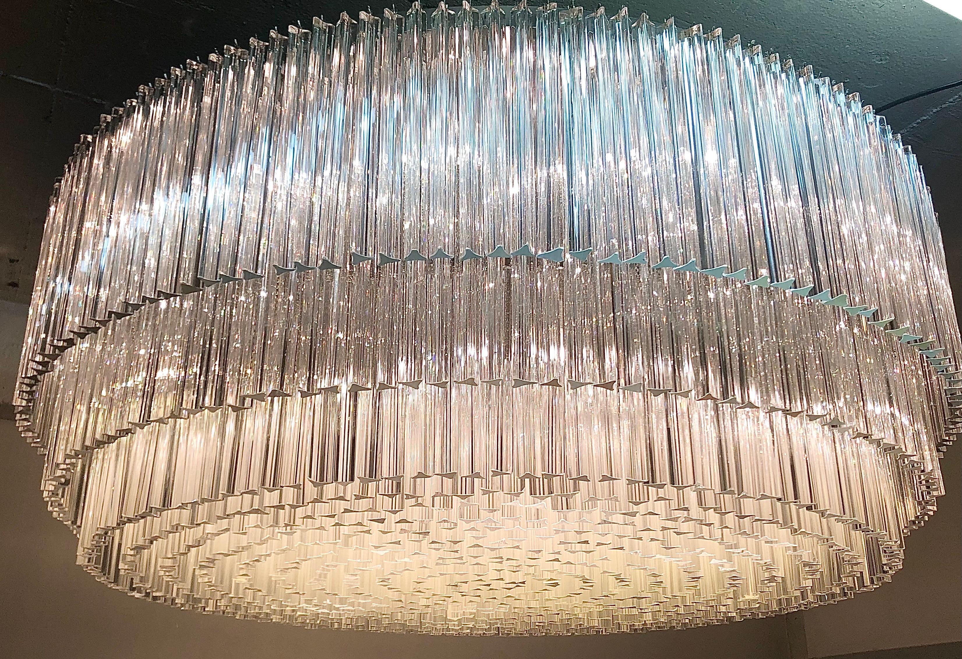 Spettacolare e monumentale lampadario rotondo italiano composto da 13 livelli a cascata di prismi di vetro triedri in stile Murano montati su una solida struttura in ferro. L'anello esterno è nichelato e lucido, mentre la struttura interna presenta