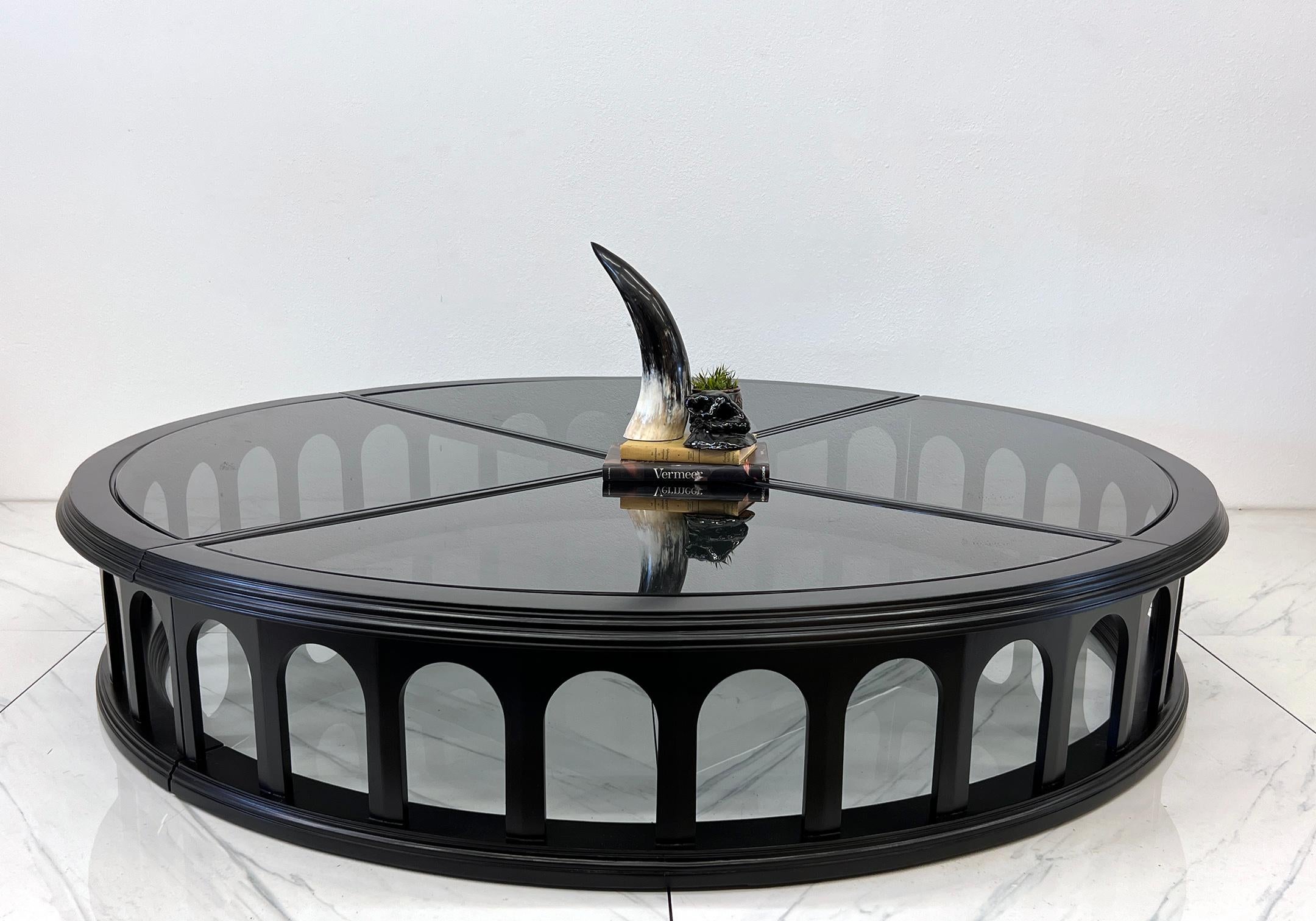Lorsque nous disons que cette table basse est monumentale, nous le pensons littéralement : cette stupéfiante beauté architecturale circulaire semble avoir été réduite à un colisée romain, trempée dans une élégance noire de jais et agrémentée de