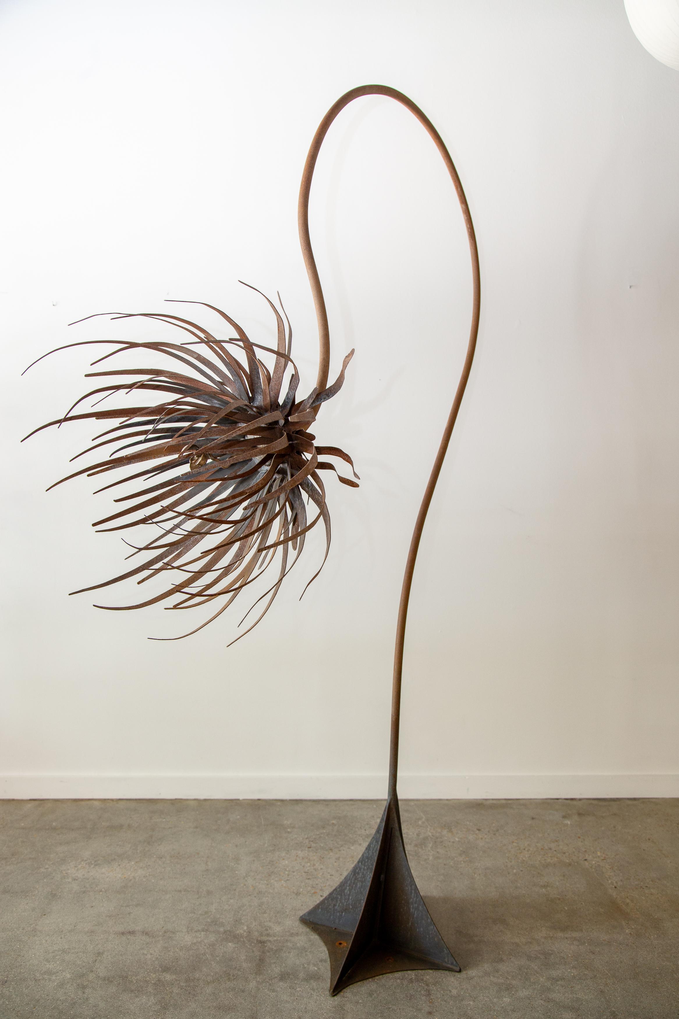 A monumental sculpture in patinated steel and cast bronze. A large swooping arm gives a fantastical feel.  Individual petals of thin iron cut and welded into a wide sepal bouquet. The stamen center piece in cast bronze is an unexpected counterpart