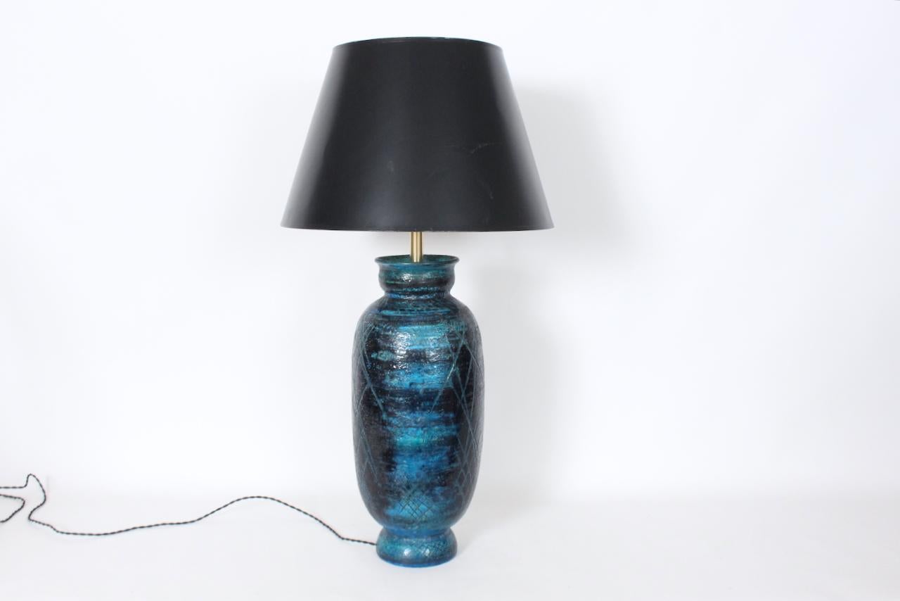 Larger Aldo for Bitossi Incised Rimini Blue Pottery Table Lamp. Featuring a handcrafted glazed, footed olive jar form, incised, cross hatch accents with Rimini Blue and Black with Ink Blue, Sea Green highlights. 6.5D footed circular base. With Brass