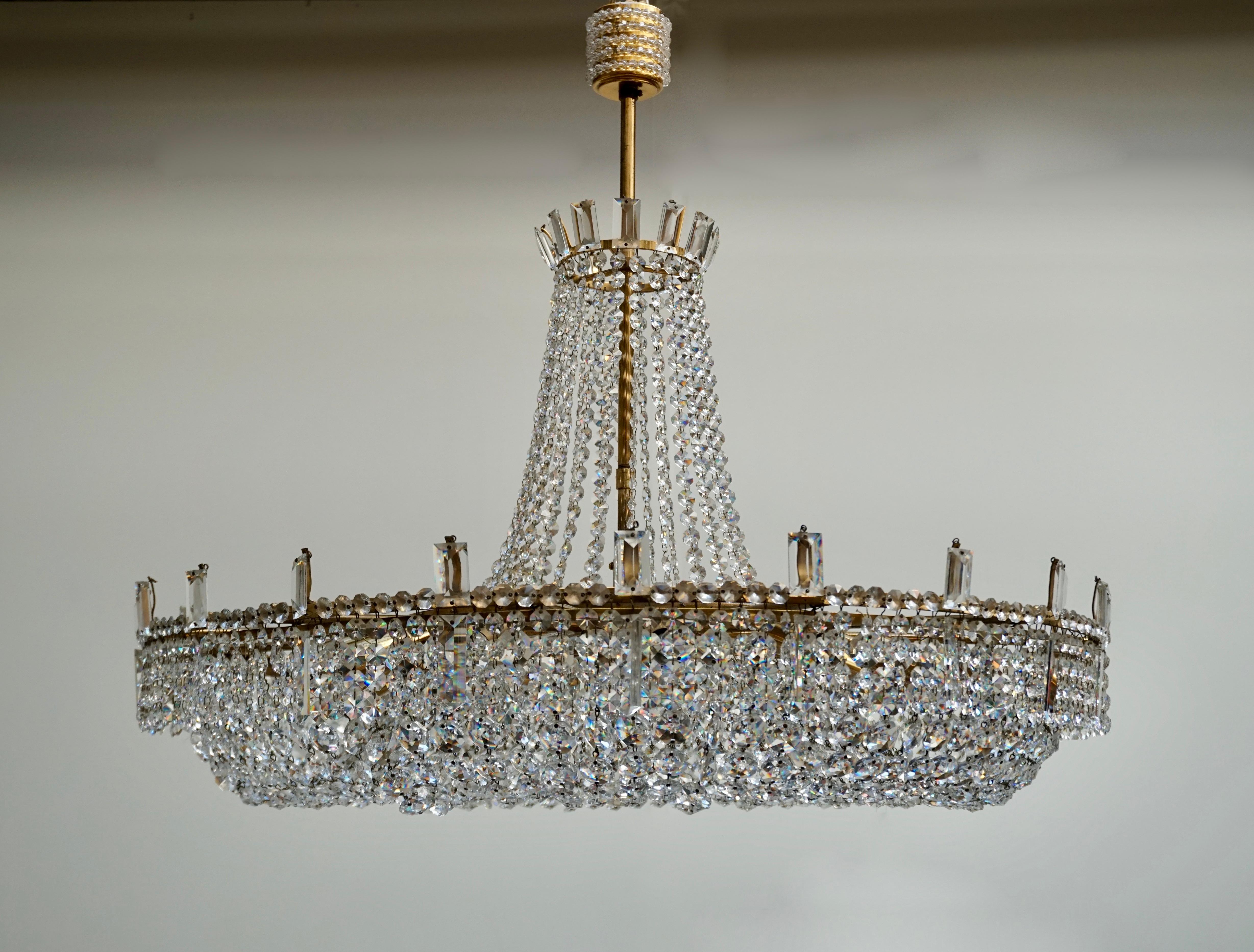 A stunning chandelier made of crystal beads and handcut crystal prisms, all mounted on a polished brass frame, Italy, circa 1950. 
The light requires twelve single E14 screw fit lightbulbs (60Watt max.) LED compatible.

Measures: Diameter 80