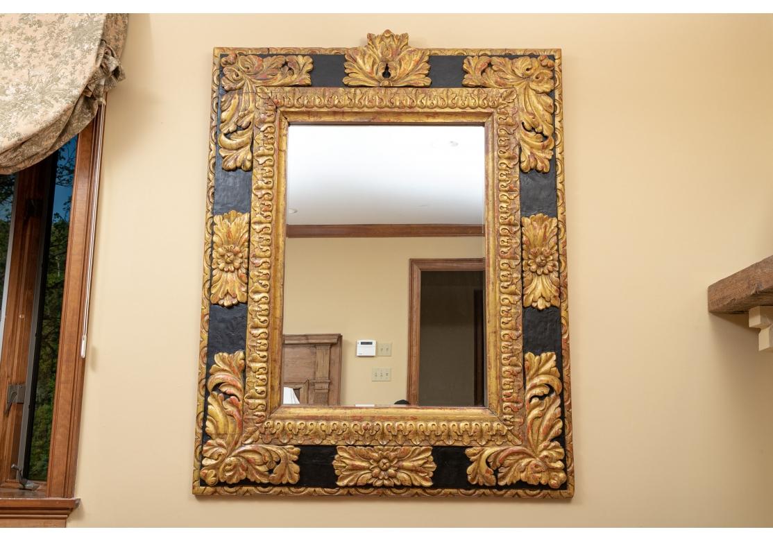 With a wide outer surround painted black with large scale red and gilt relief decoration with acanthus leaves and rosettes. A gilt leafy band for the inner surround.
Measures: height. 60
